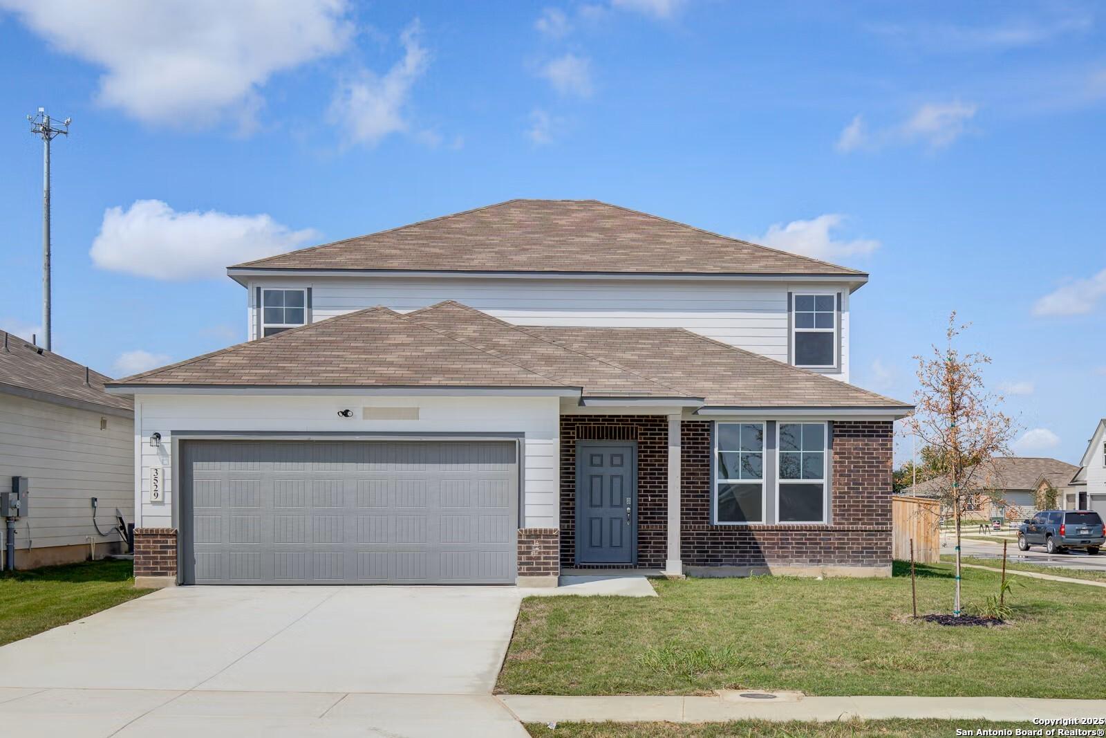 Modern two-story Douglas B home by Davidson Homes with 2-car garage, brick accents, and front lawn in Hannah Heights, Seguin, Texas