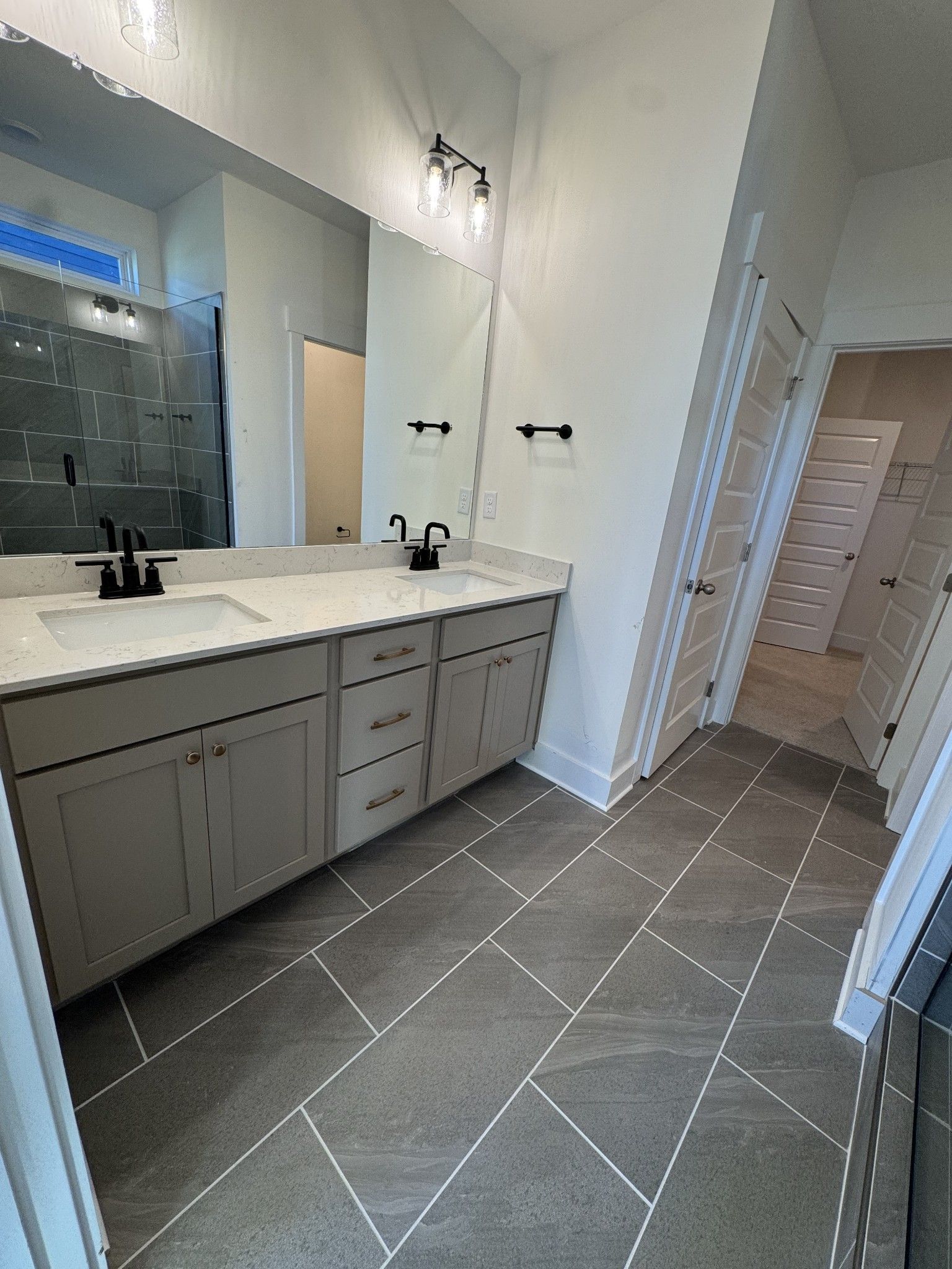 Elegant master bathroom with double vanity, quartz counters, frameless glass shower in Davidson Homes The Ash A, Gallatin, TN