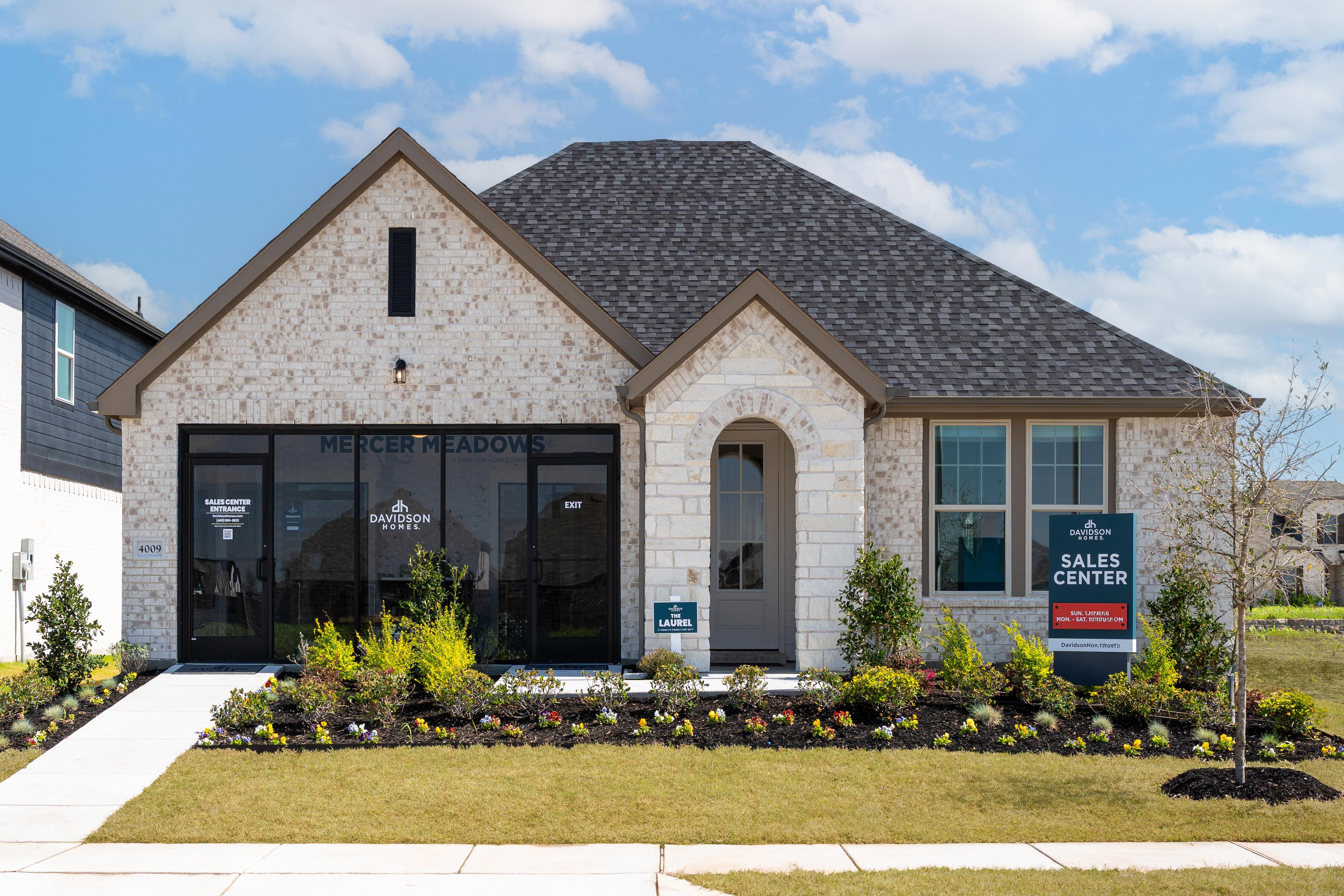 Davidson Homes sales center at Mercer Meadows in Royse City Texas with brick facade arched entry and landscaped front