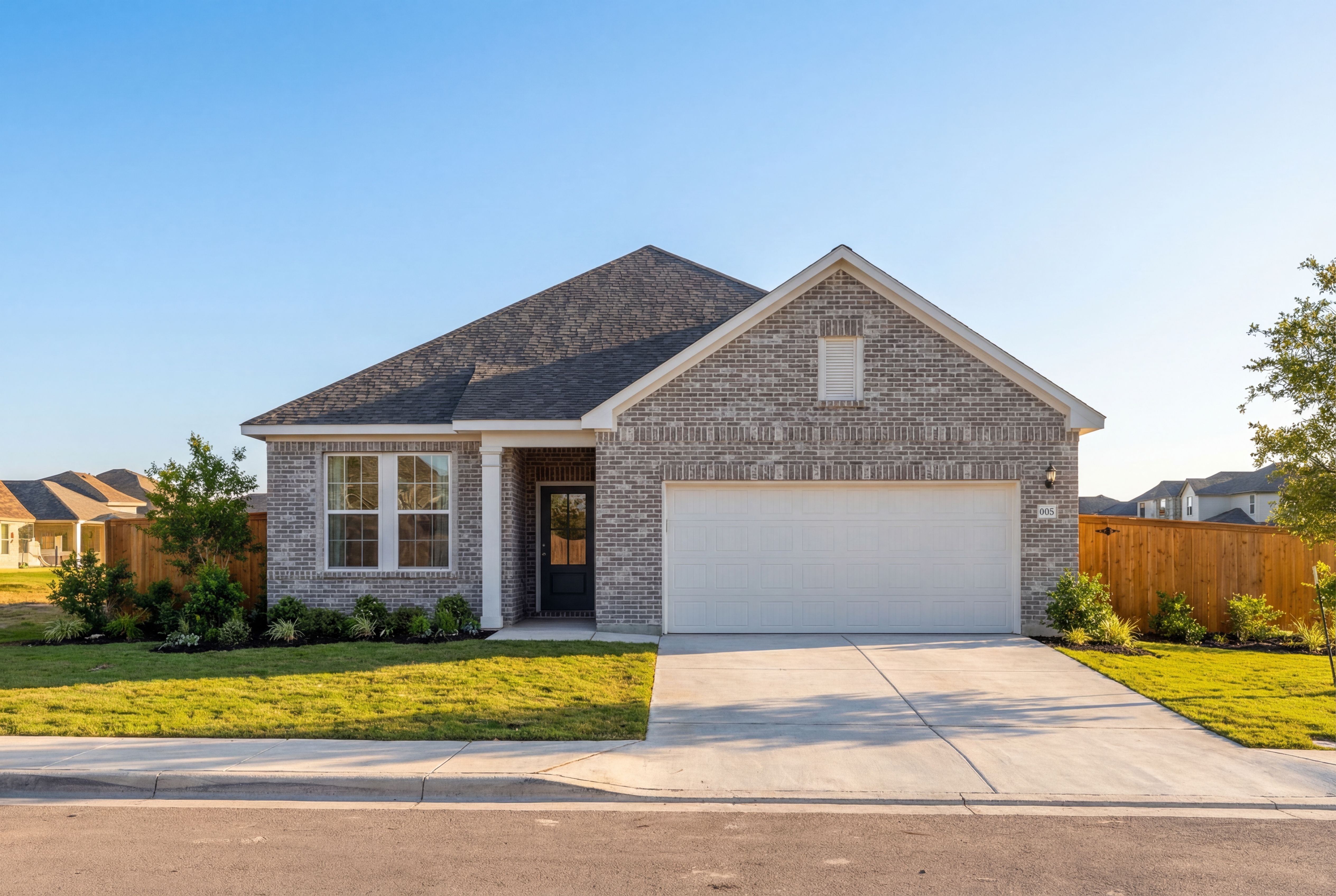 Modern brick facade of The Glenwood I 1-story home featuring 2-car garage, gabled roof, and landscaped yard in San Antonio