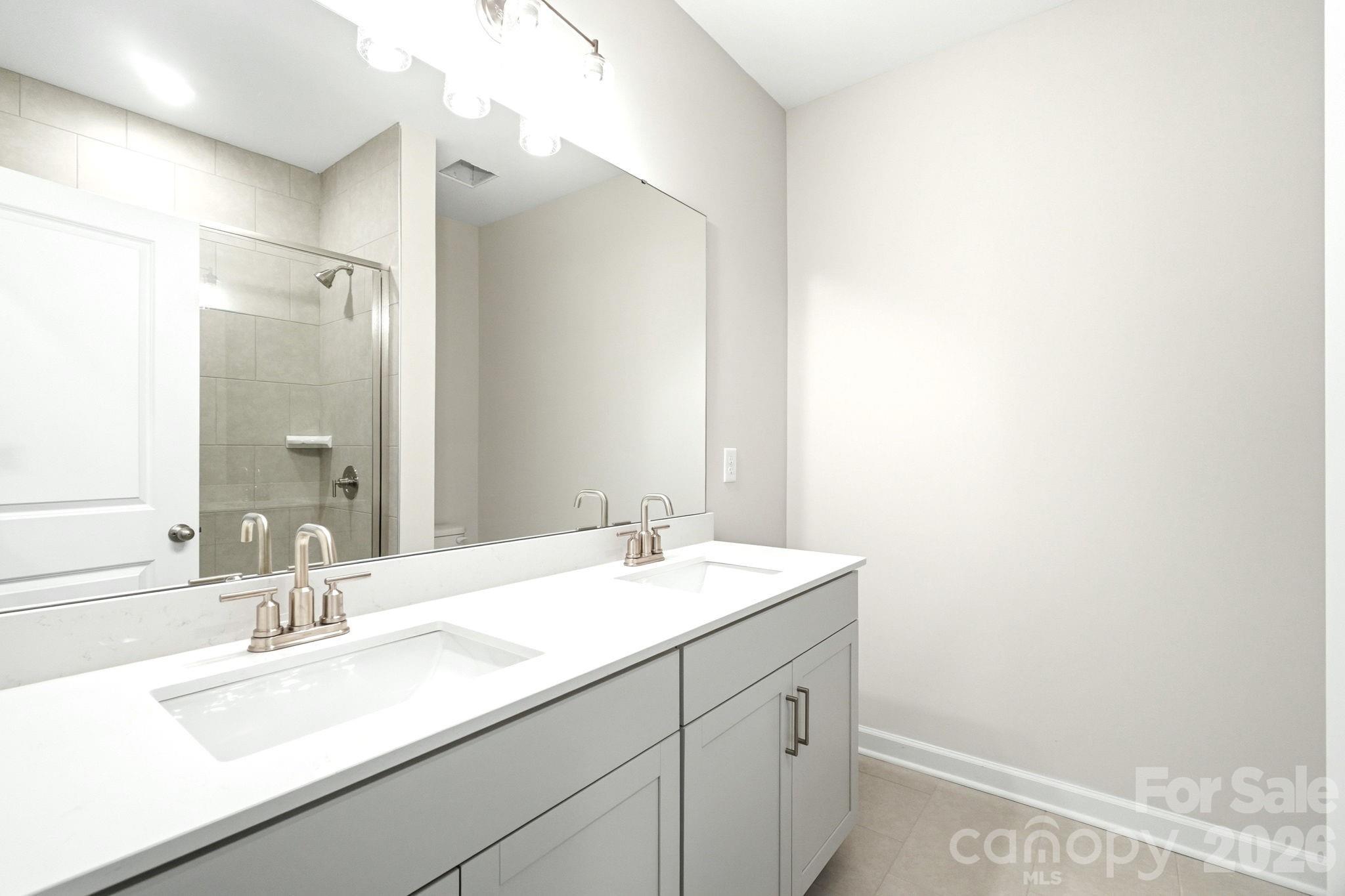 Modern dual-sink vanity with white countertops in Magnolia B floor plan home, Windgate, Mooresville, North Carolina.