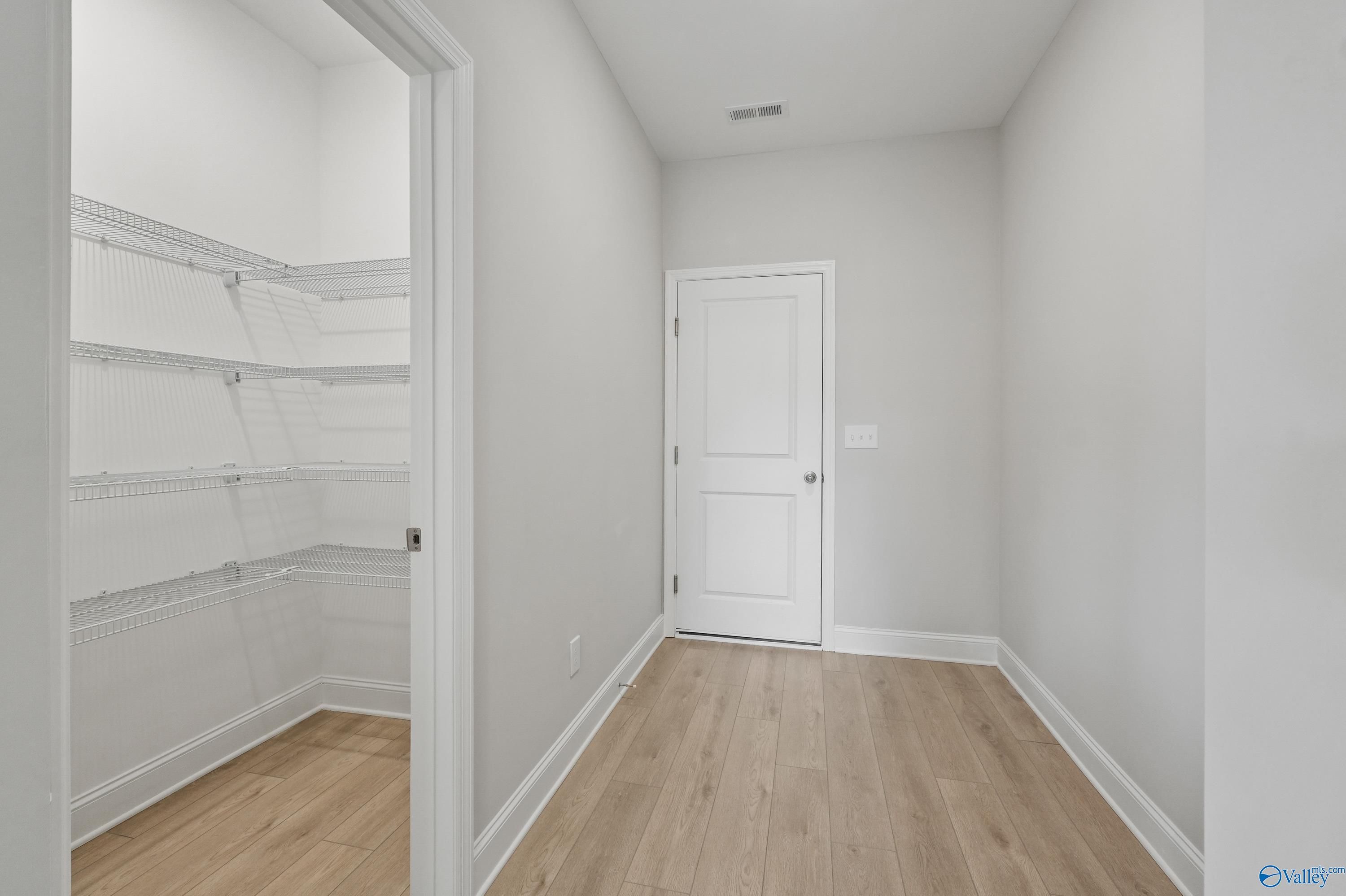 Spacious walk-in closet with wire shelving and light oak floors in Davidson Homes The Camden B, Pavilion, Huntsville