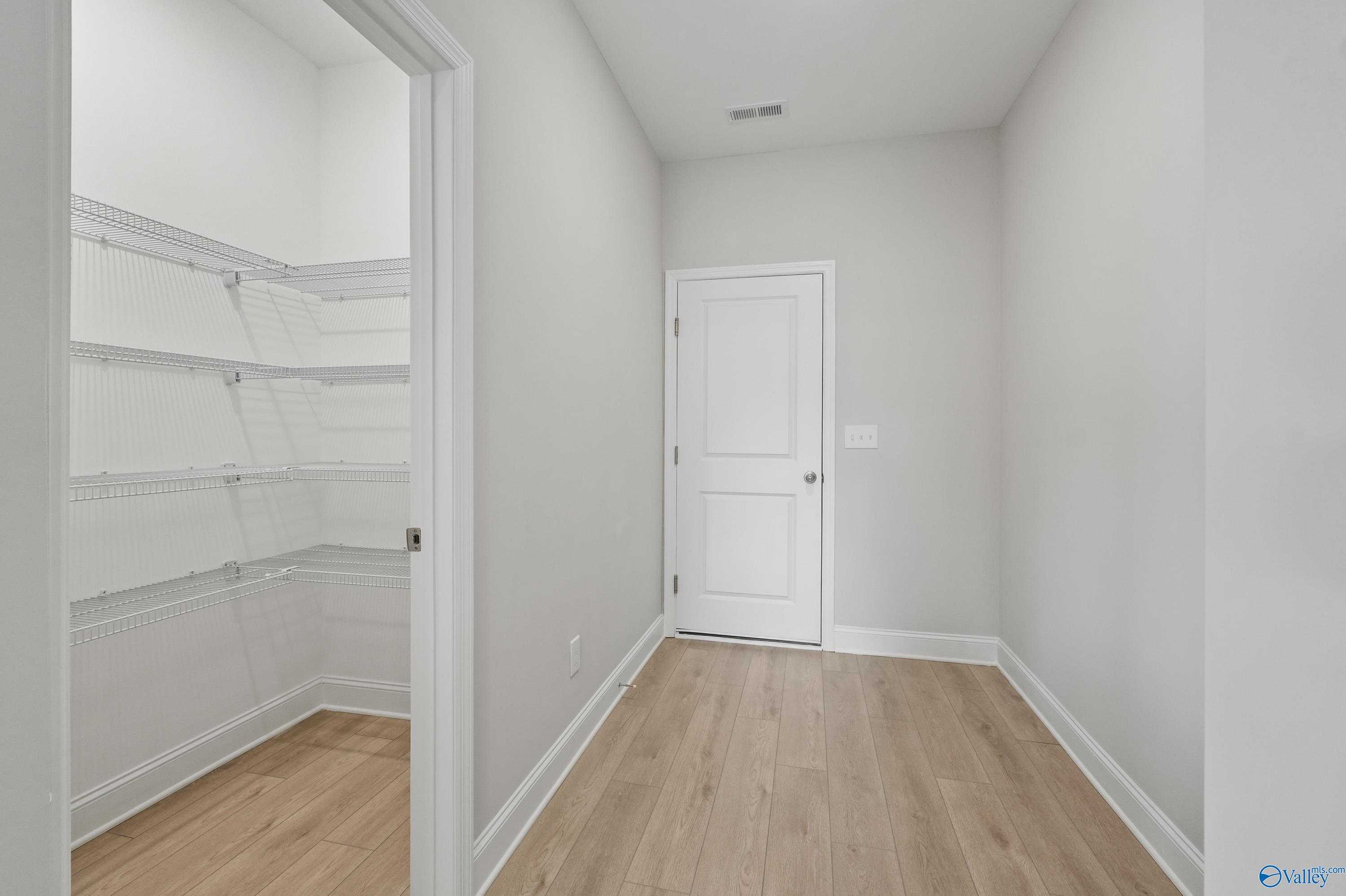 Spacious walk-in closet with wire shelving and light oak floors in Davidson Homes The Camden B, Pavilion, Huntsville