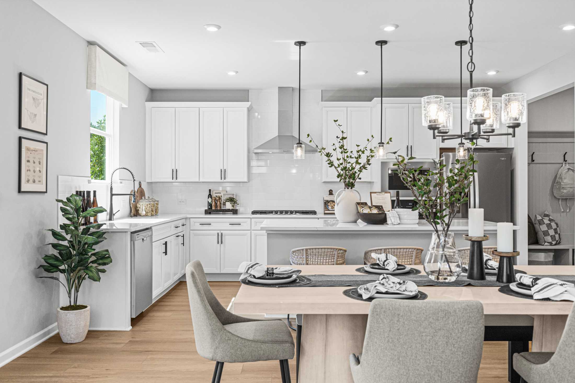 Modern kitchen in The Hickory A with white shaker cabinets, stainless appliances, large island, and open dining space