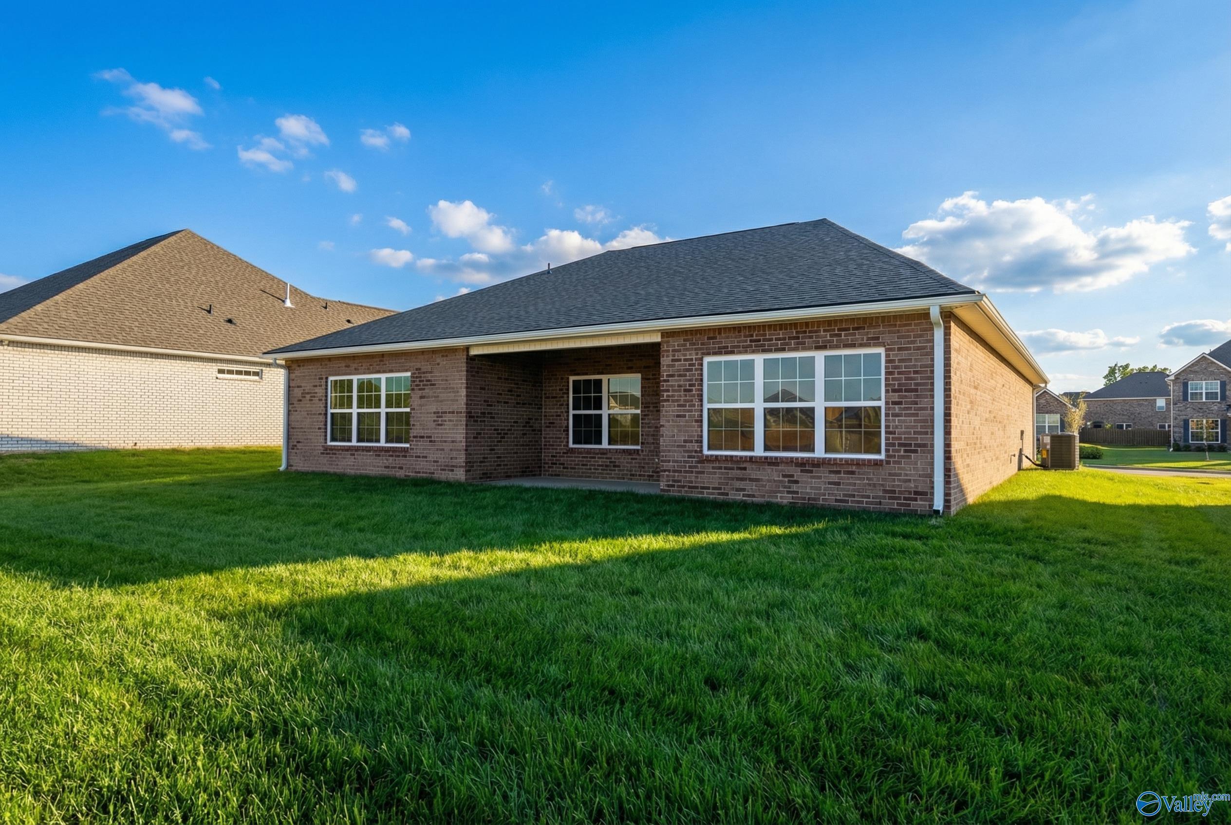 Single-story brick 3-bedroom home with 2-car garage, covered entry, and lush green lawn in Creekside, Harvest, Alabama by Davidson Homes