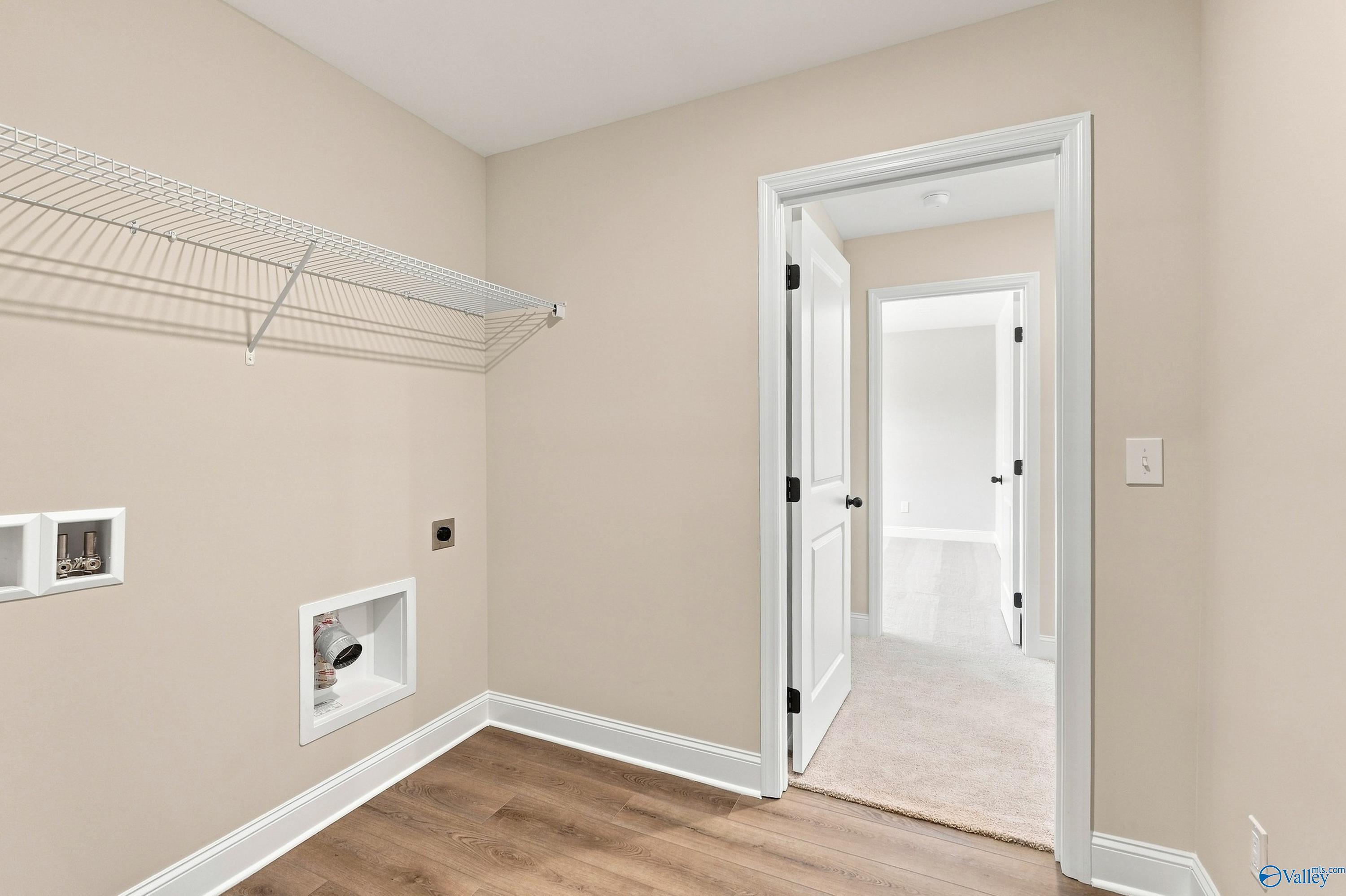Laundry room with wire shelving, washer connections, and wood-look flooring in Davidson Homes The Chelsea B, Creek Grove, New Market, AL
