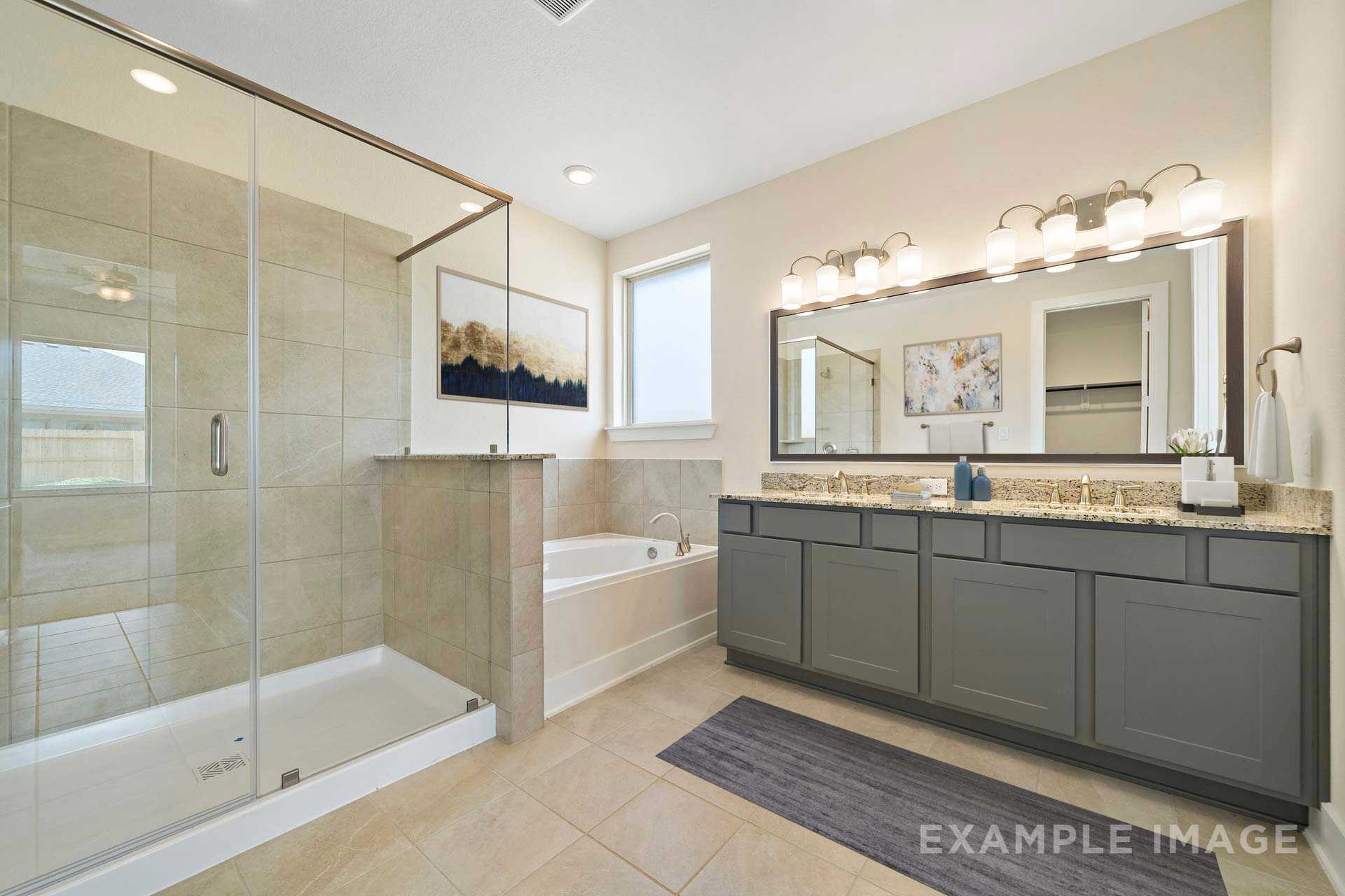 Spacious master bathroom in The Diana C featuring glass-enclosed shower, soaking tub, and double vanity