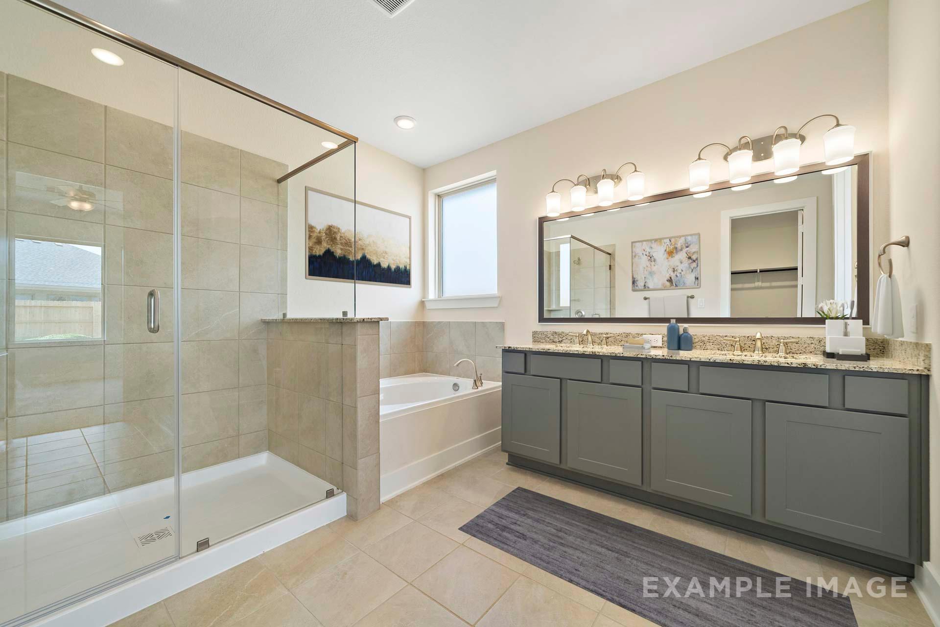 Spacious master bathroom in The Diana C featuring glass-enclosed shower, soaking tub, and double vanity