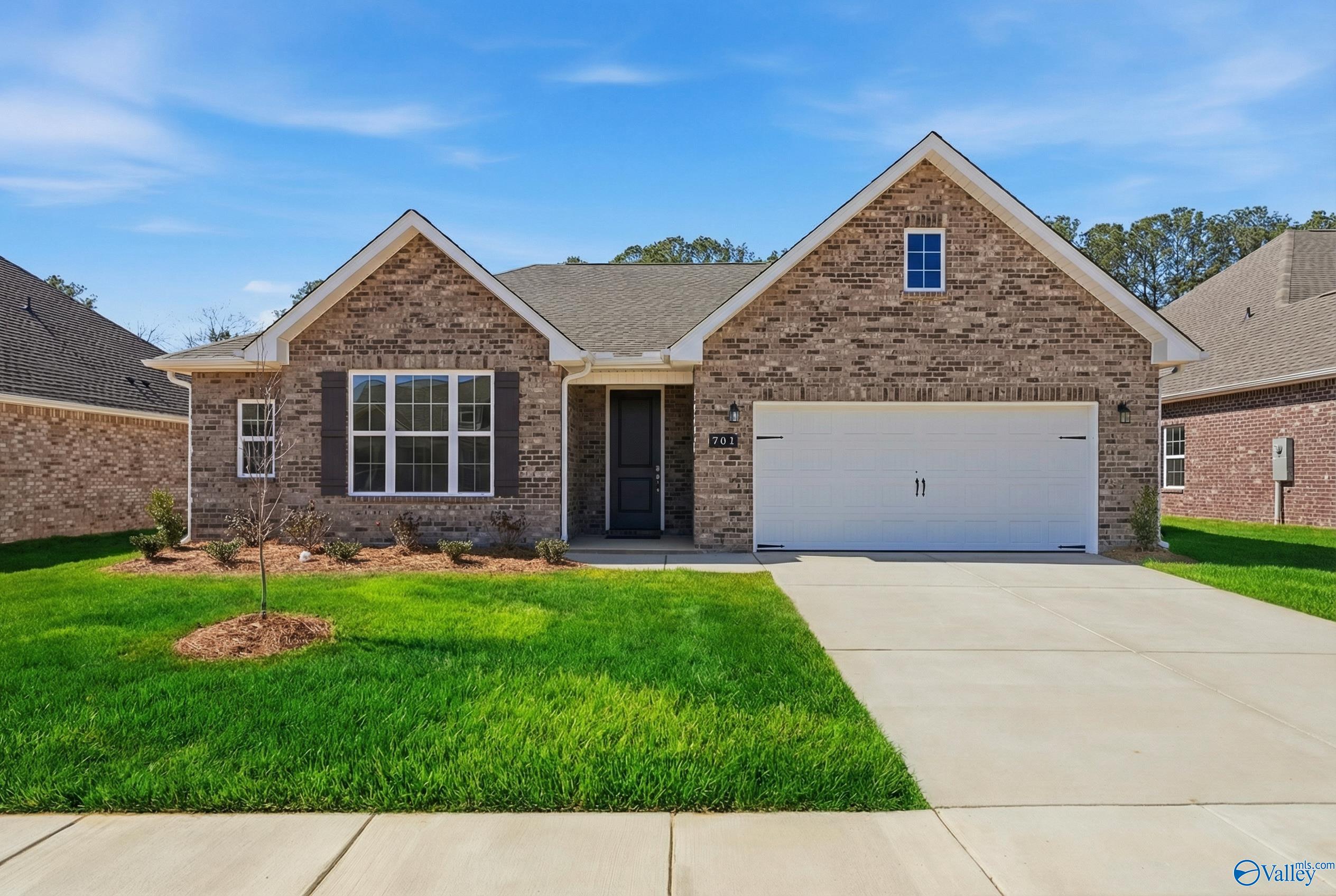 Modern brick 1-story home with 2-car garage, gabled roof, and manicured lawn in Cain Park, Hartselle, Alabama - Davidson Homes The Montgomery