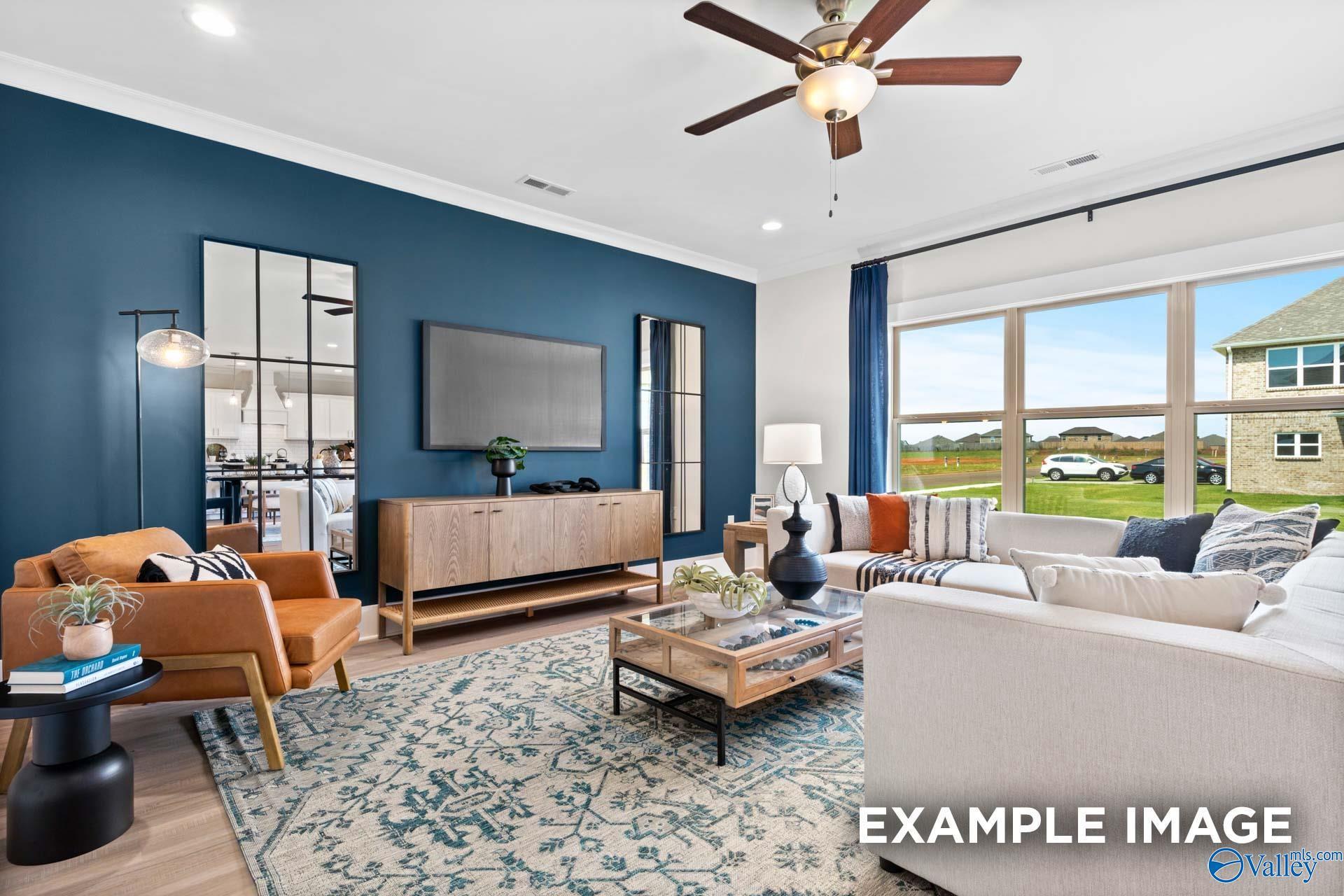 Modern living room with blue accent wall in The Chelsea B floor plan at Ramsay Cove, Owens Cross Roads, Alabama.