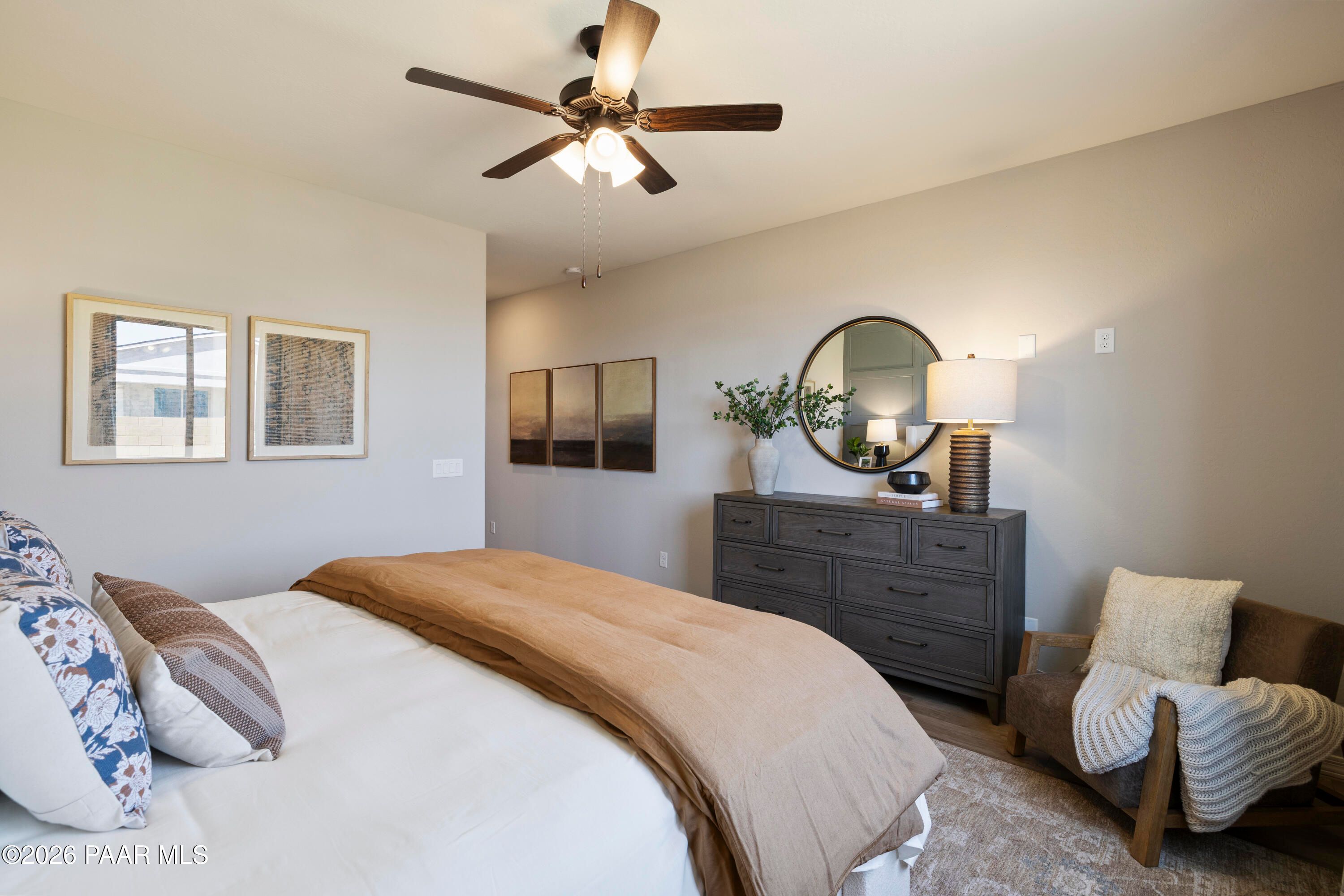 Cozy bedroom with ceiling fan and farmhouse decor in The Harmony A floor plan at North Ridge, Pronghorn Ranch, Prescott.