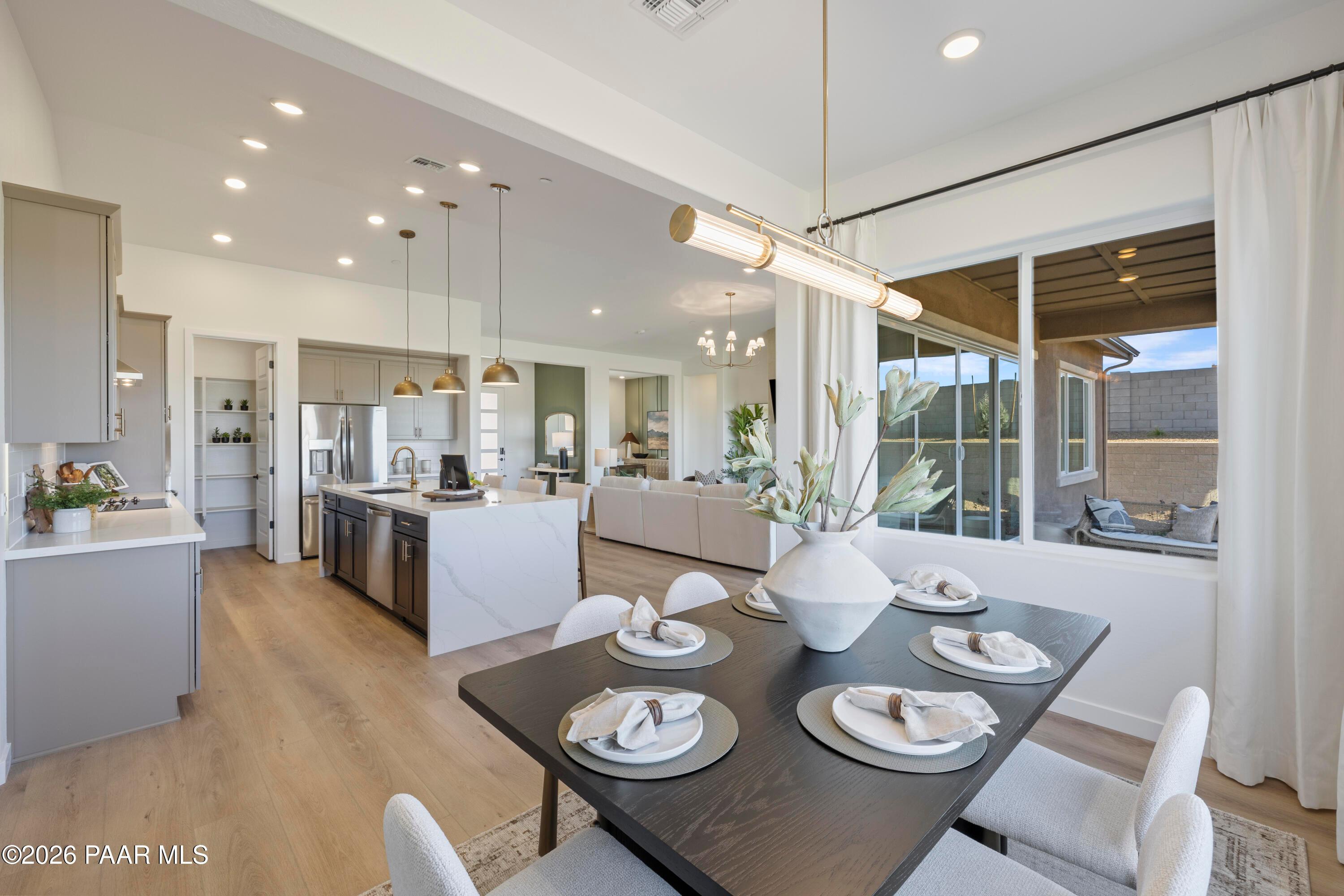Open-concept dining and kitchen with quartz island in The Blaze D floor plan at Hidden Hills, Prescott, Arizona.
