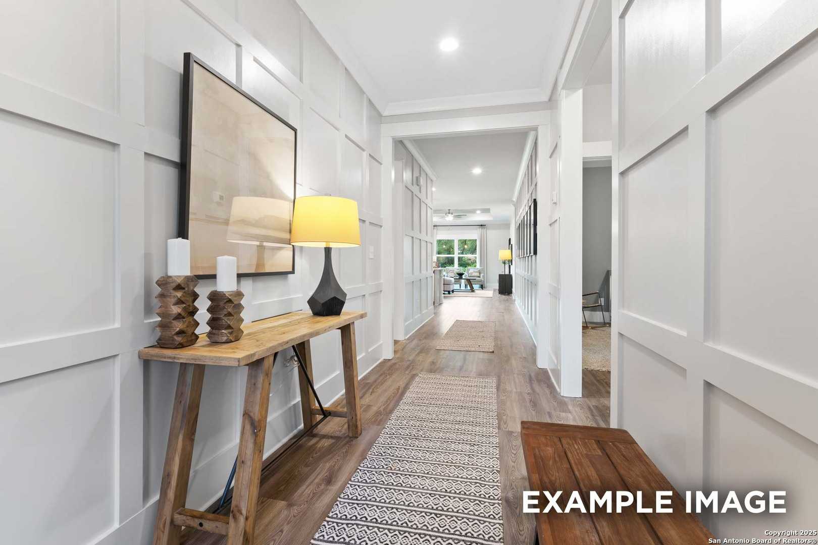 Elegant hallway with white shiplap walls, wooden console table, yellow lamp, bench, and runner rug in Davidson Homes The Daphne H, Seguin, Texas