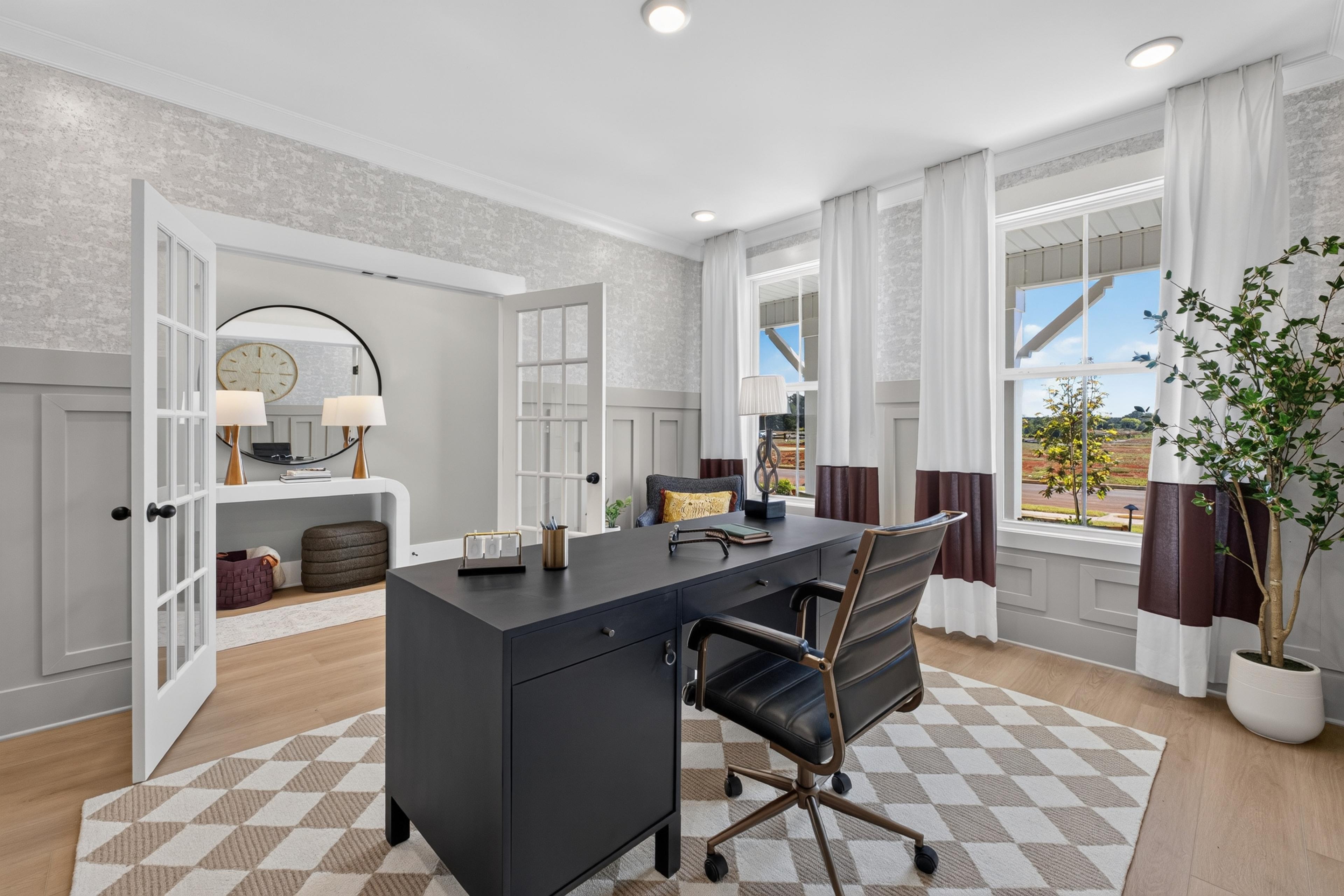 Home office with black desk and French doors at Evergreen Mill by Davidson Homes in Madison, Alabama