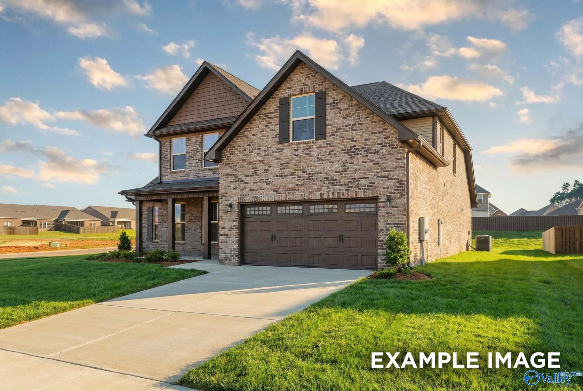 Two-story brick home with 2-car garage, driveway, and lush lawn in Hollon Meadow, Decatur, Alabama - Davidson Homes The Emory