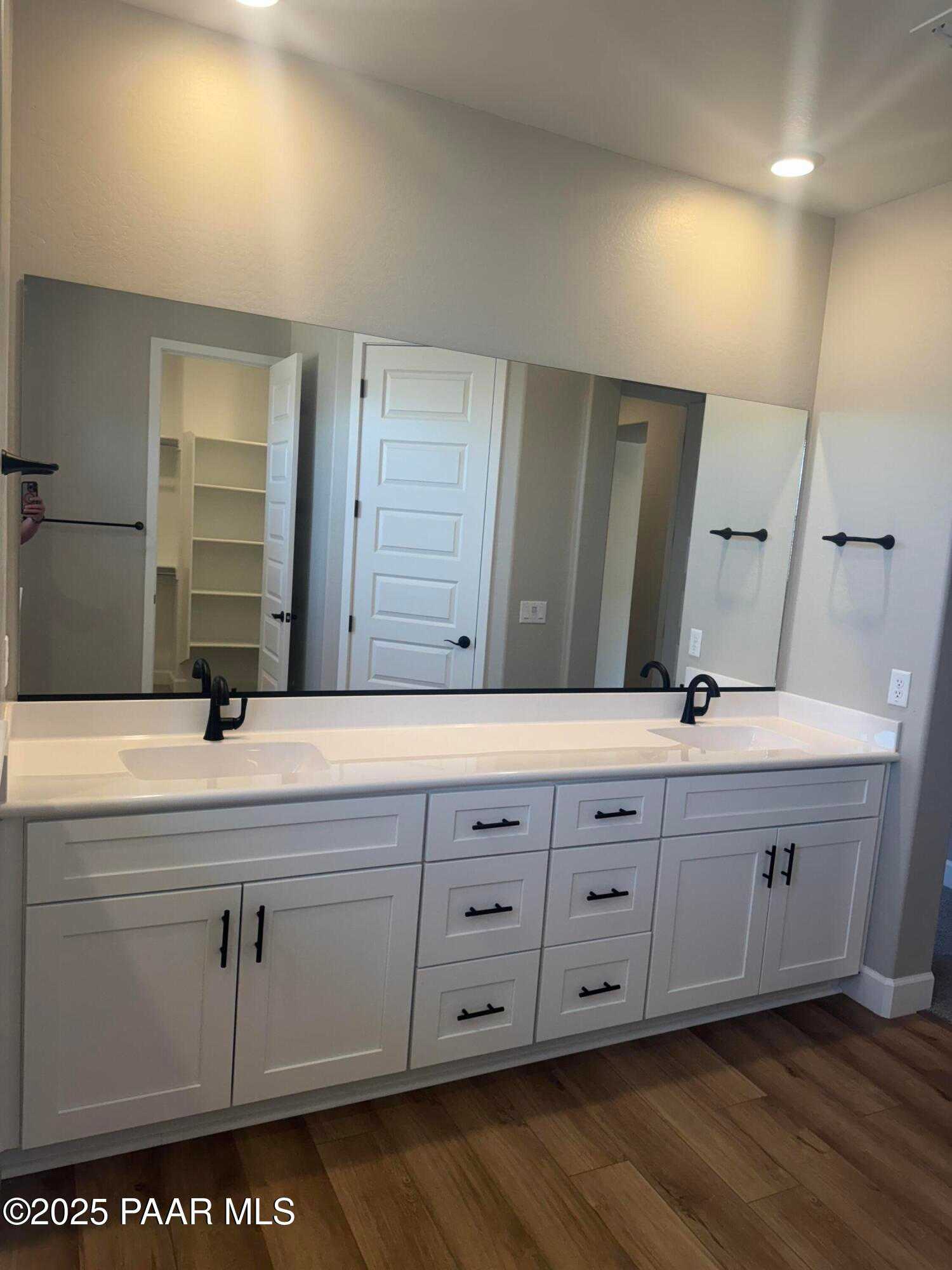 Modern double vanity with white cabinets, dual sinks, and mirrors in master bath of The Summit B by Evermore Homes, Prescott Valley, AZ
