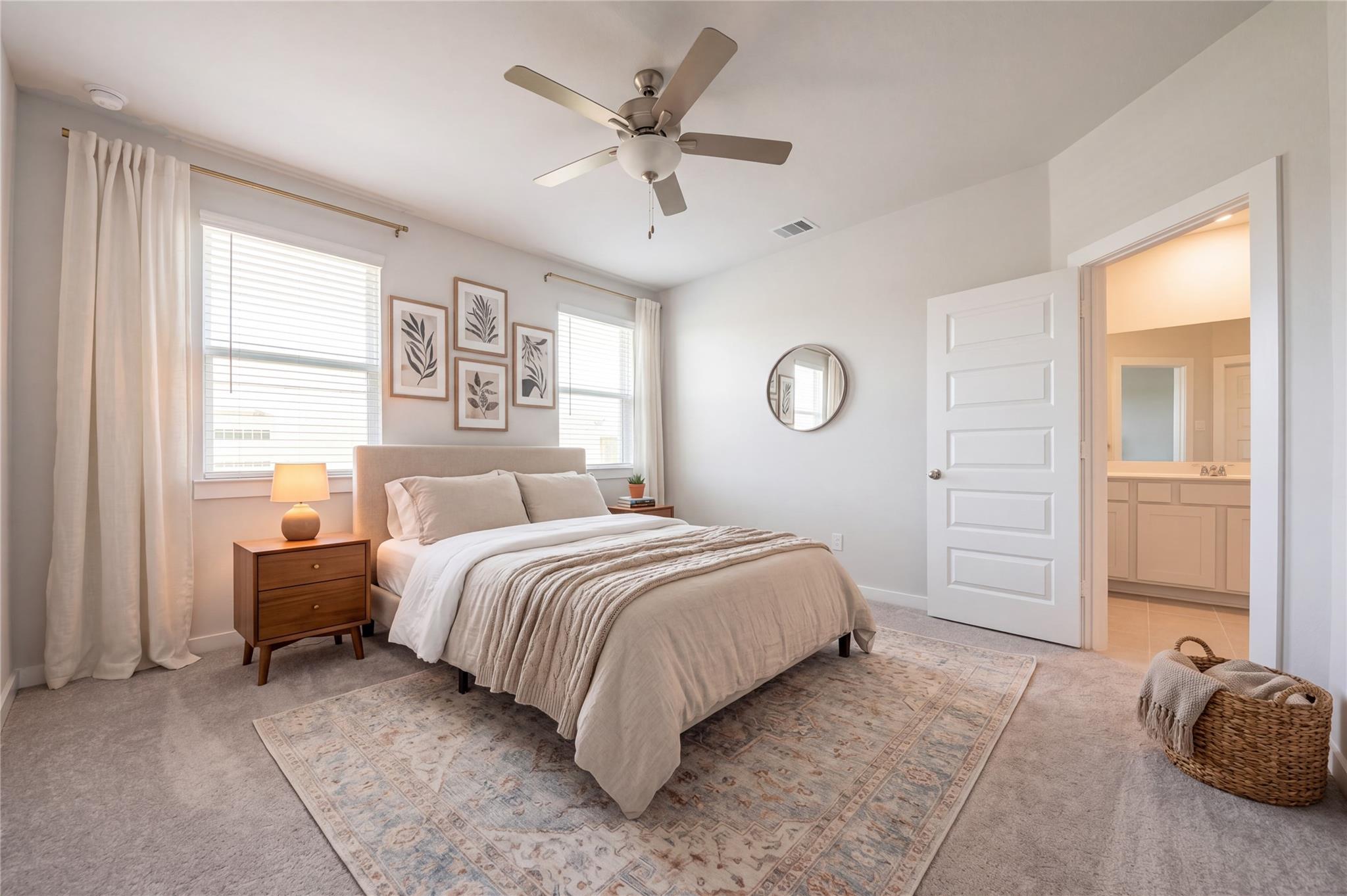 Bright primary bedroom with ceiling fan, neutral bedding, and en-suite bath in Davidson Homes' Costa A, Emberly, Beasley TX