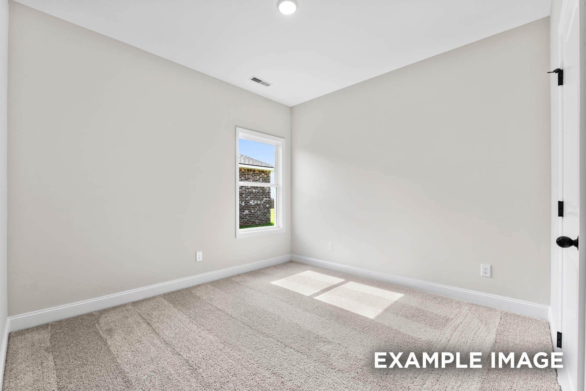 Bright, neutral bedroom with plush carpet in The Franklin E floor plan at Bailey Park in Fayetteville, Tennessee.
