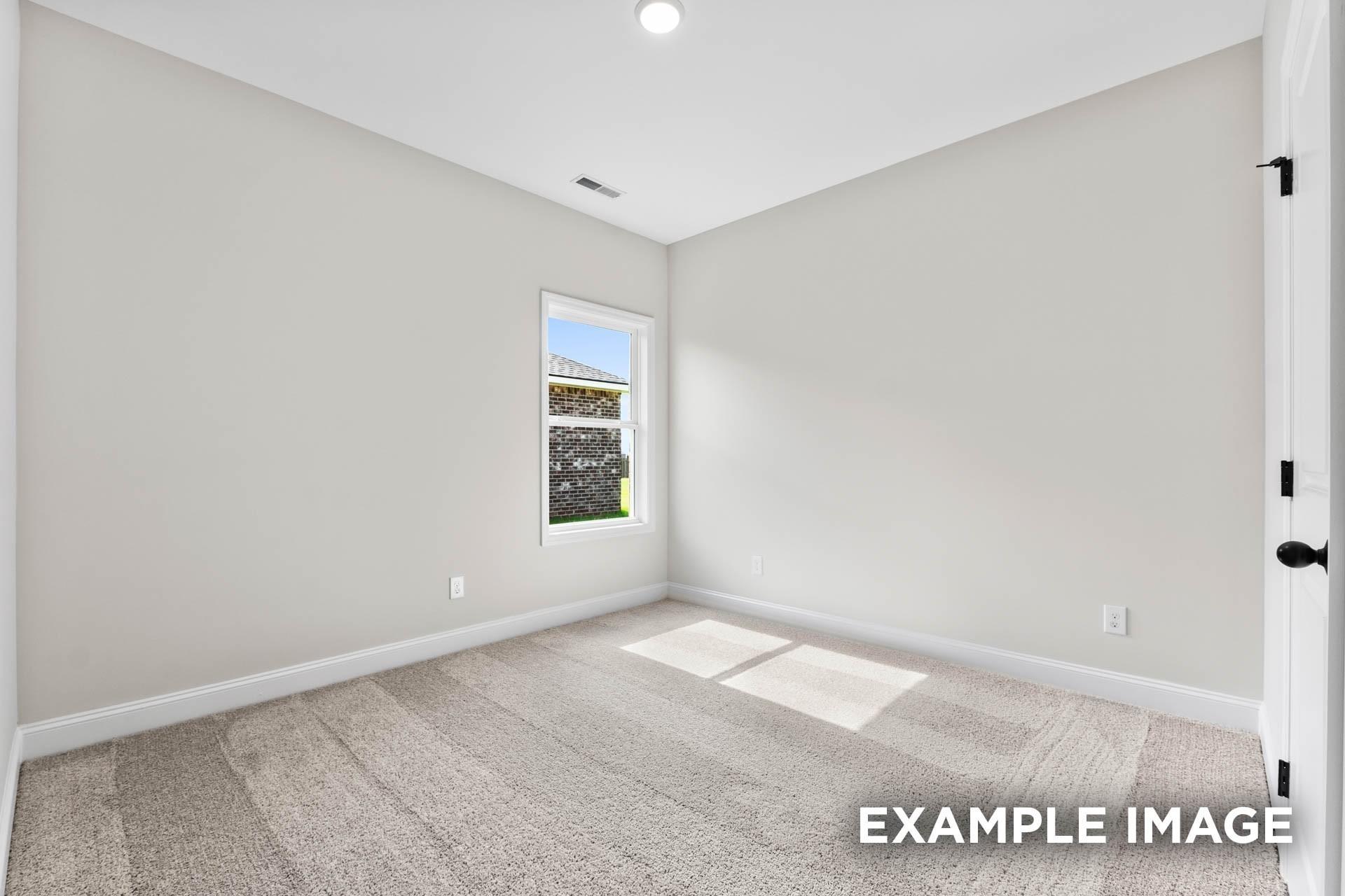 Bright, neutral bedroom with plush carpet in The Franklin E floor plan at Bailey Park in Fayetteville, Tennessee.