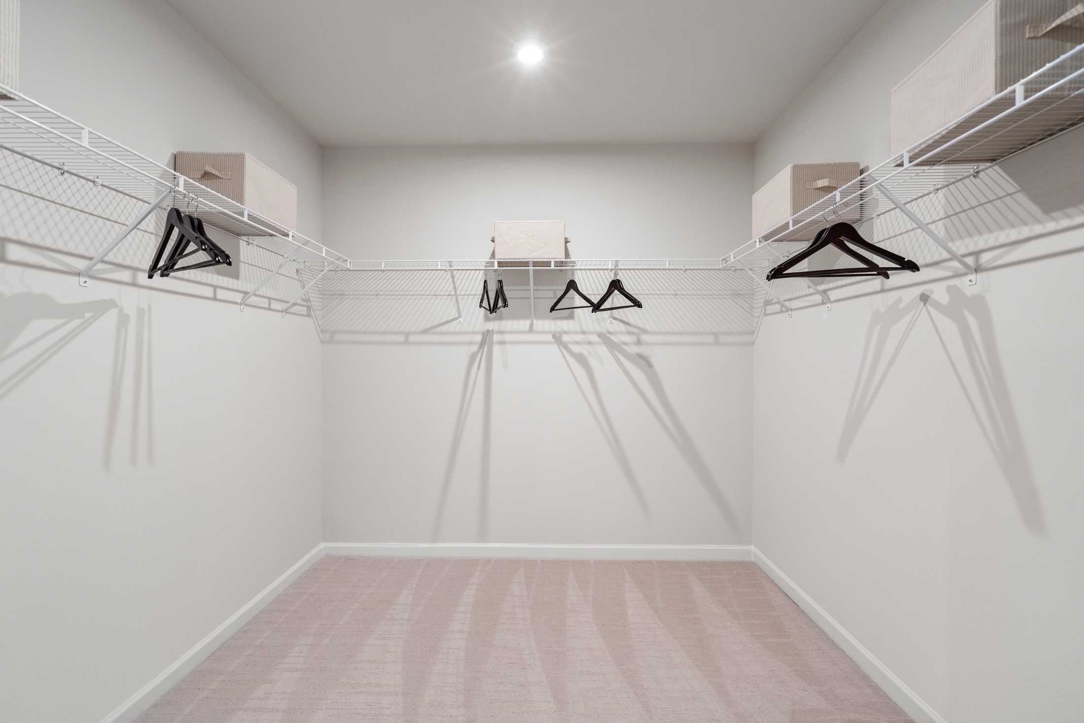 Spacious walk-in closet in The Marion B master suite featuring wire shelving, hanging rods, and beige carpet