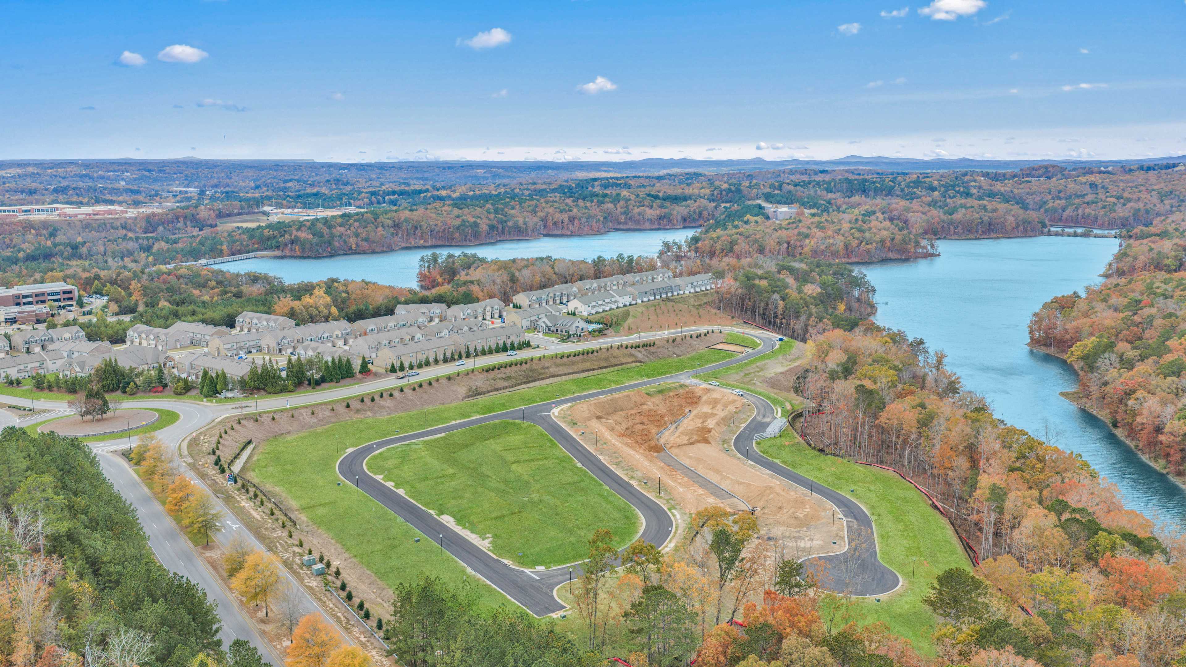 Spacious modern kitchen at The Bluffs in Canton GA by Davidson Homes with white cabinetry, stainless steel appliances, and island bar