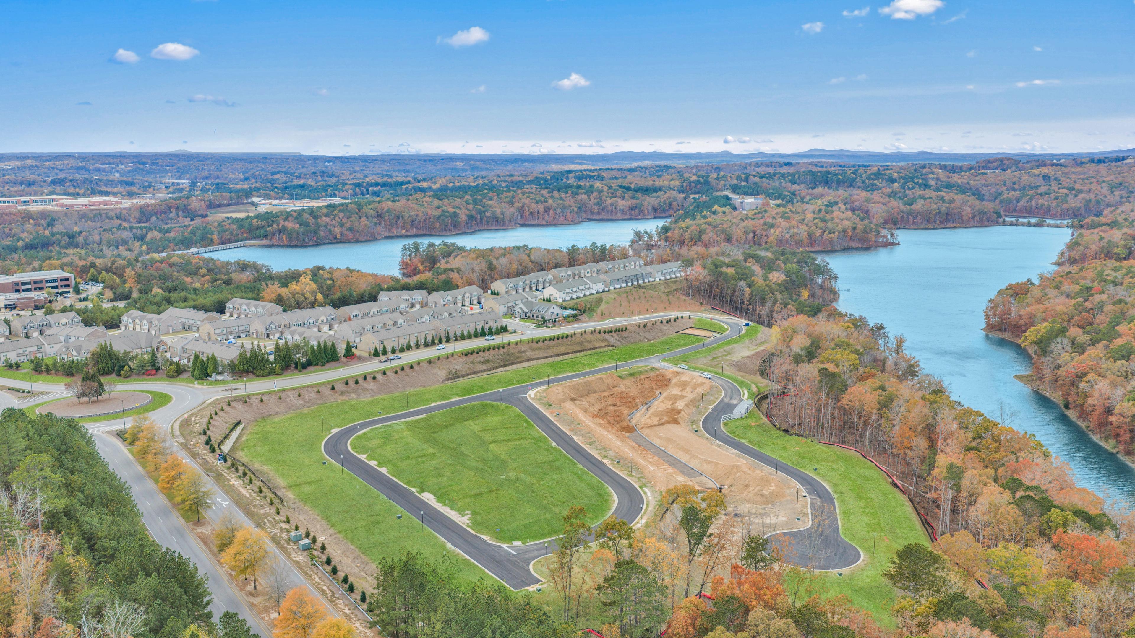 Spacious modern kitchen at The Bluffs in Canton GA by Davidson Homes with white cabinetry, stainless steel appliances, and island bar