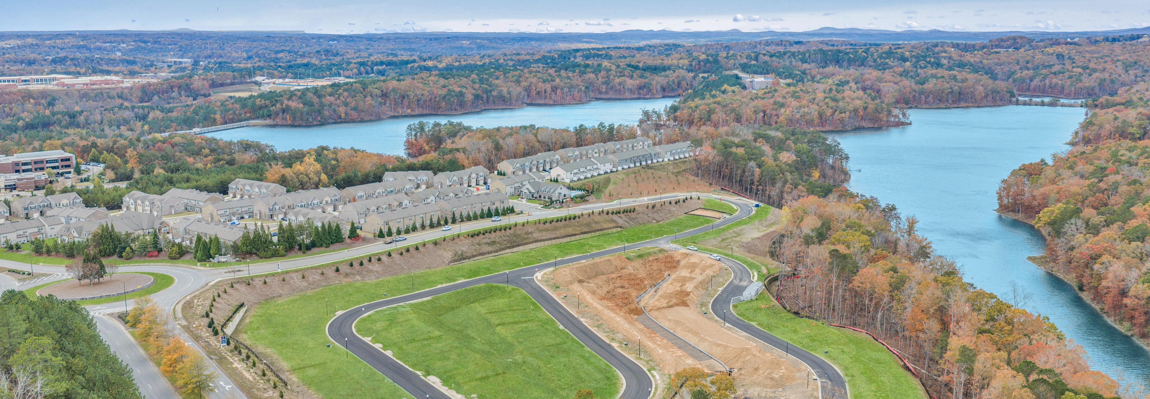 Spacious modern kitchen at The Bluffs in Canton GA by Davidson Homes with white cabinetry, stainless steel appliances, and island bar