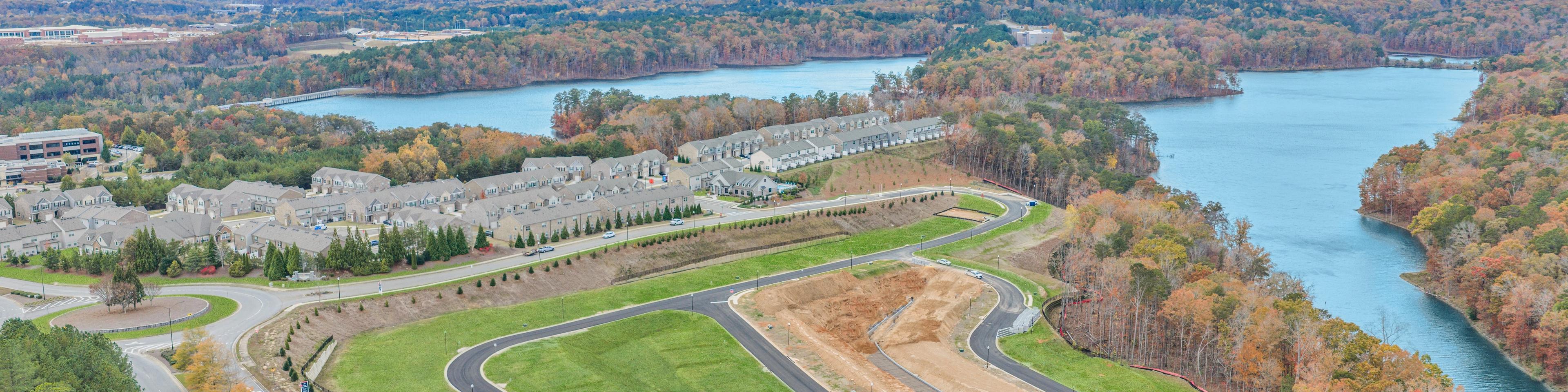 Spacious modern kitchen at The Bluffs in Canton GA by Davidson Homes with white cabinetry, stainless steel appliances, and island bar