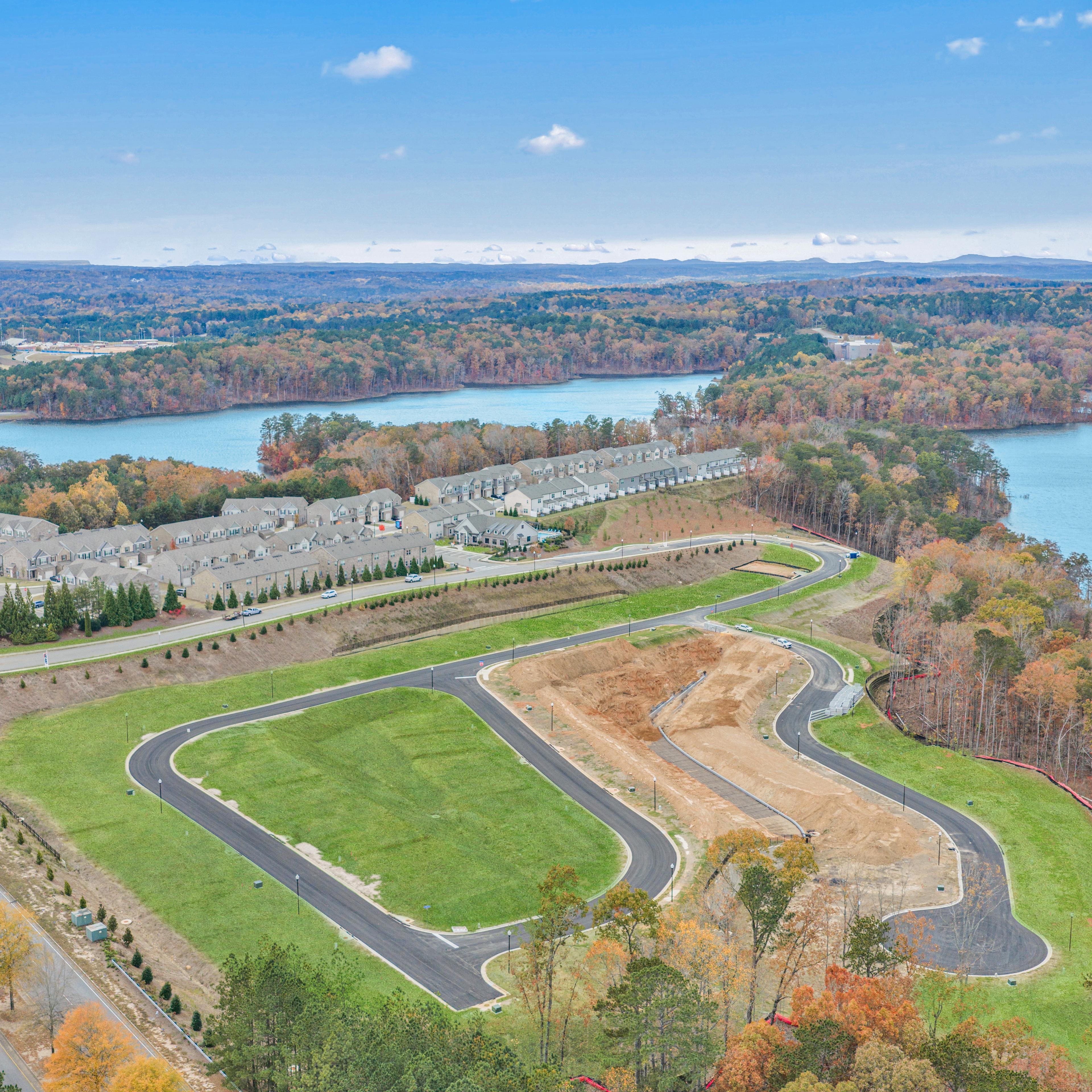 Spacious modern kitchen at The Bluffs in Canton GA by Davidson Homes with white cabinetry, stainless steel appliances, and island bar