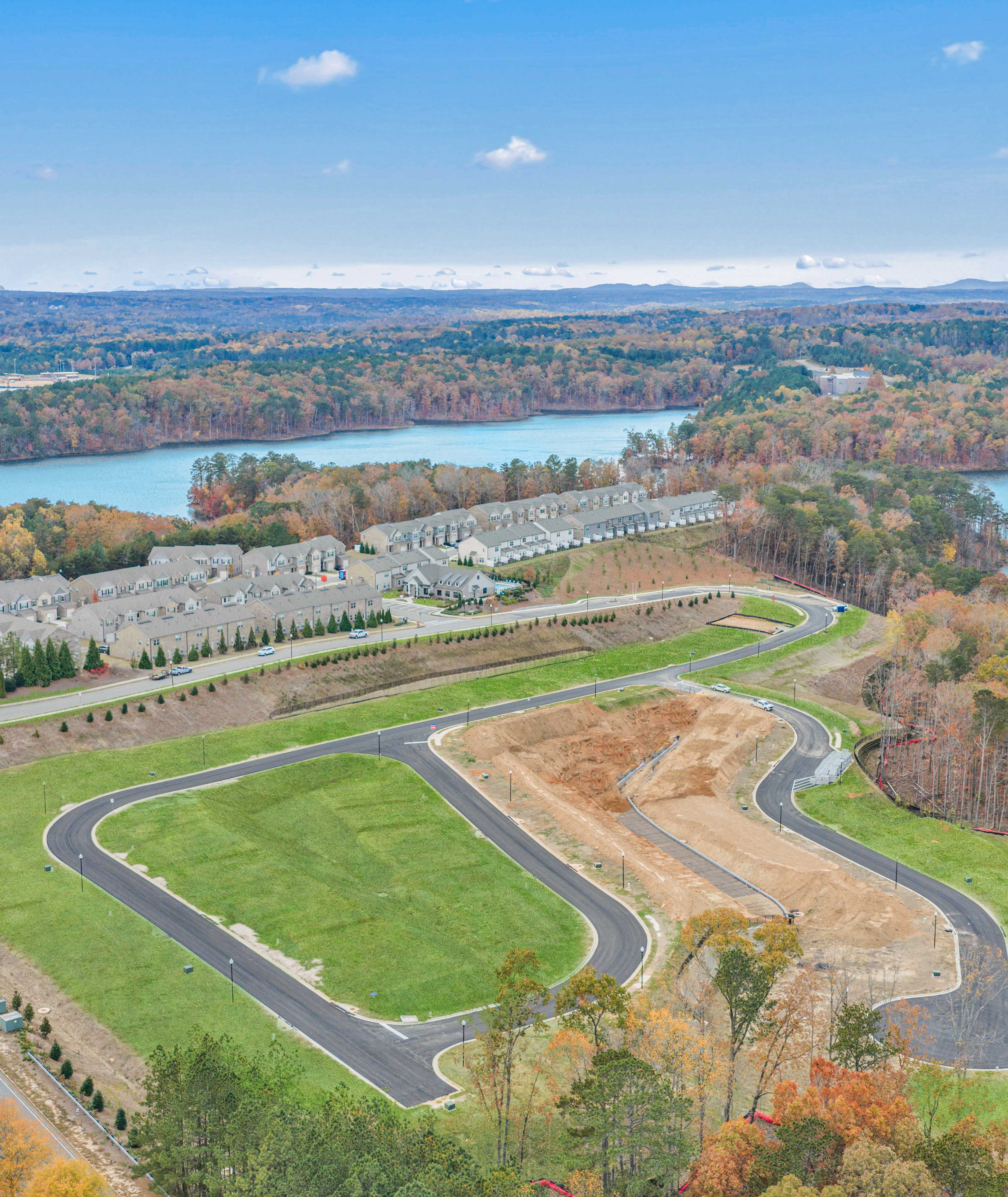 Spacious modern kitchen at The Bluffs in Canton GA by Davidson Homes with white cabinetry, stainless steel appliances, and island bar