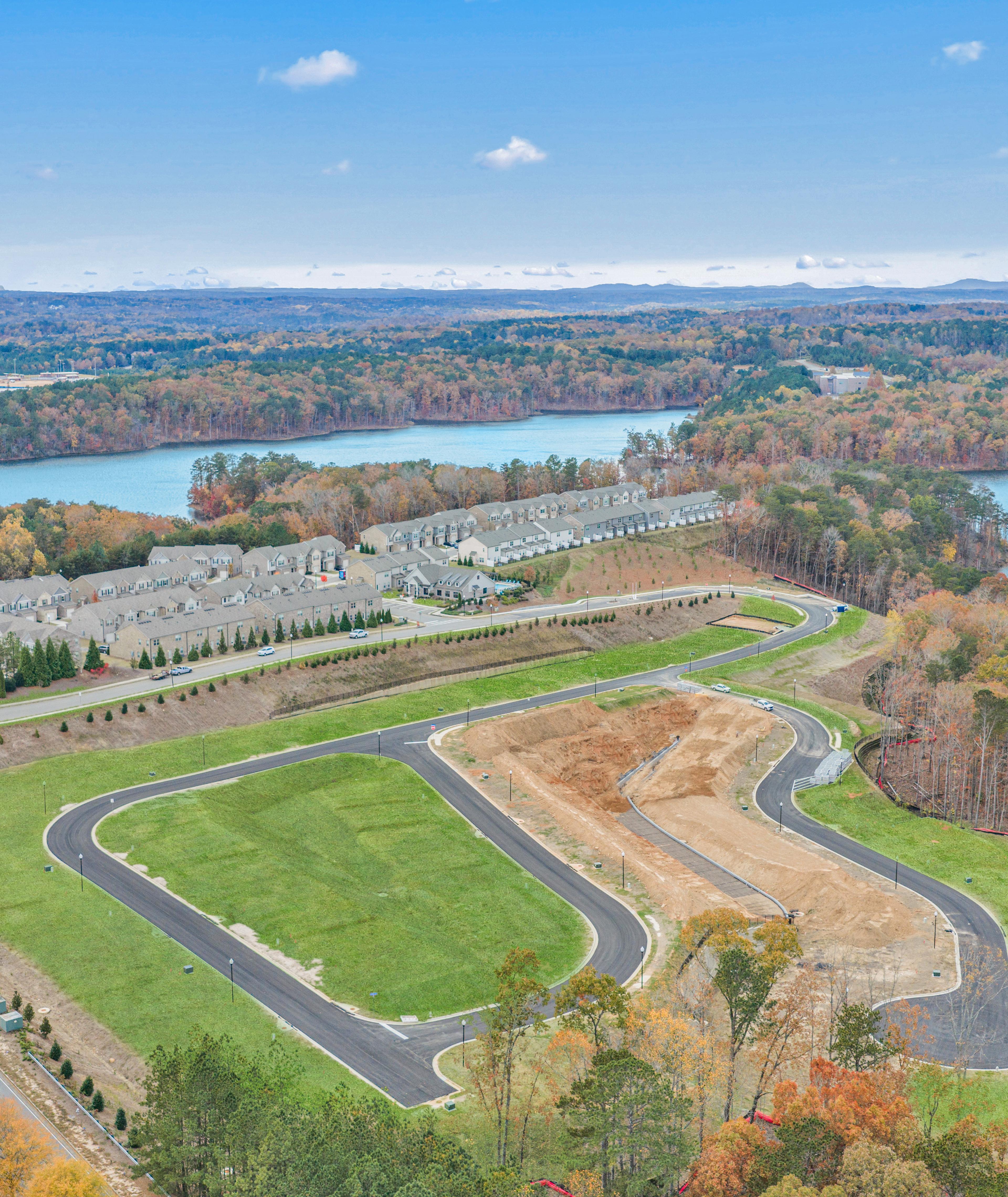 Spacious modern kitchen at The Bluffs in Canton GA by Davidson Homes with white cabinetry, stainless steel appliances, and island bar