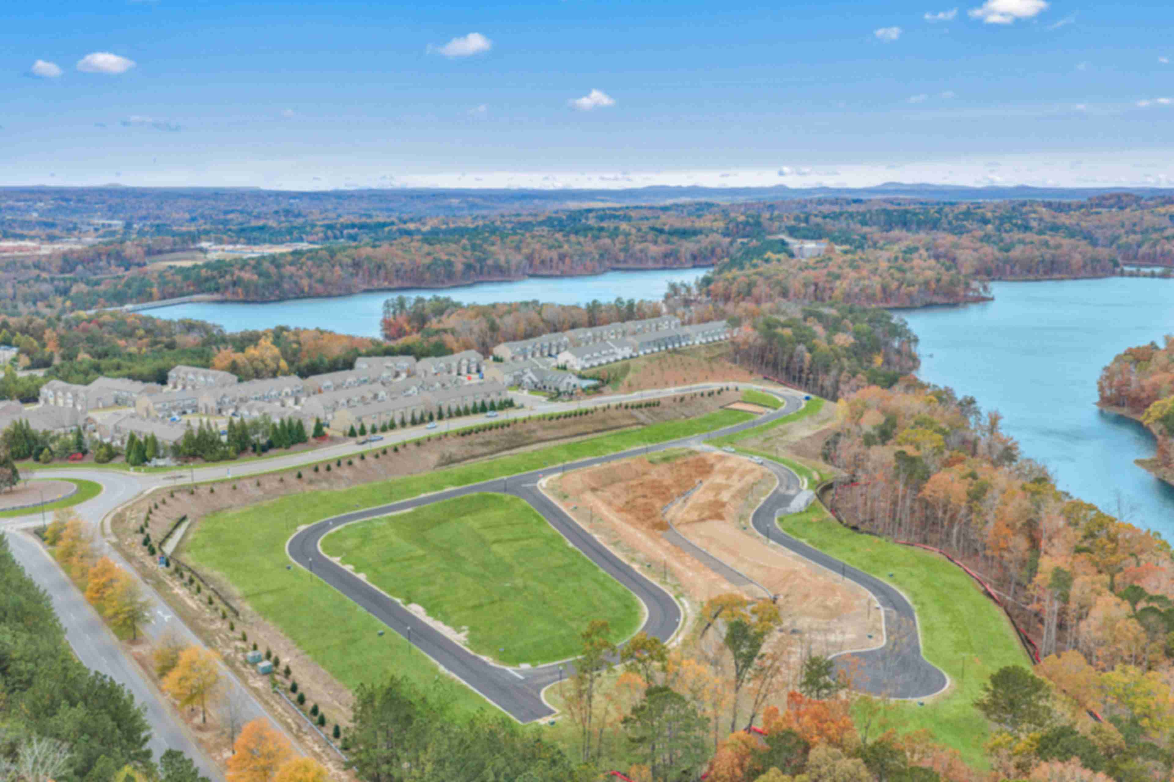 Spacious modern kitchen at The Bluffs in Canton GA by Davidson Homes with white cabinetry, stainless steel appliances, and island bar