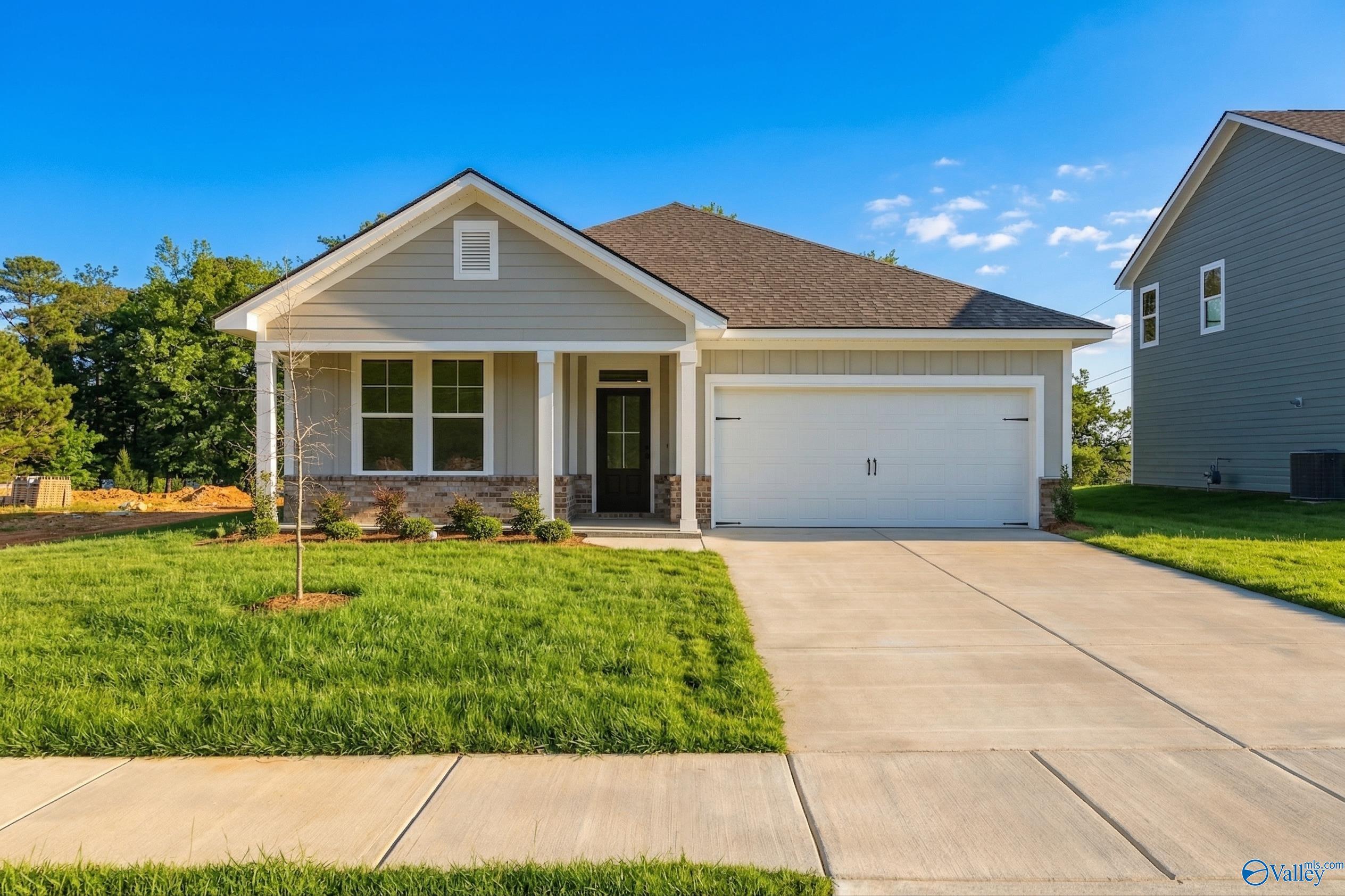 Charming single-story 3-bedroom home with 2-car garage, beige siding, and brick accents in Noble Ridge, Cullman, Alabama - Davidson Homes The Laurel K