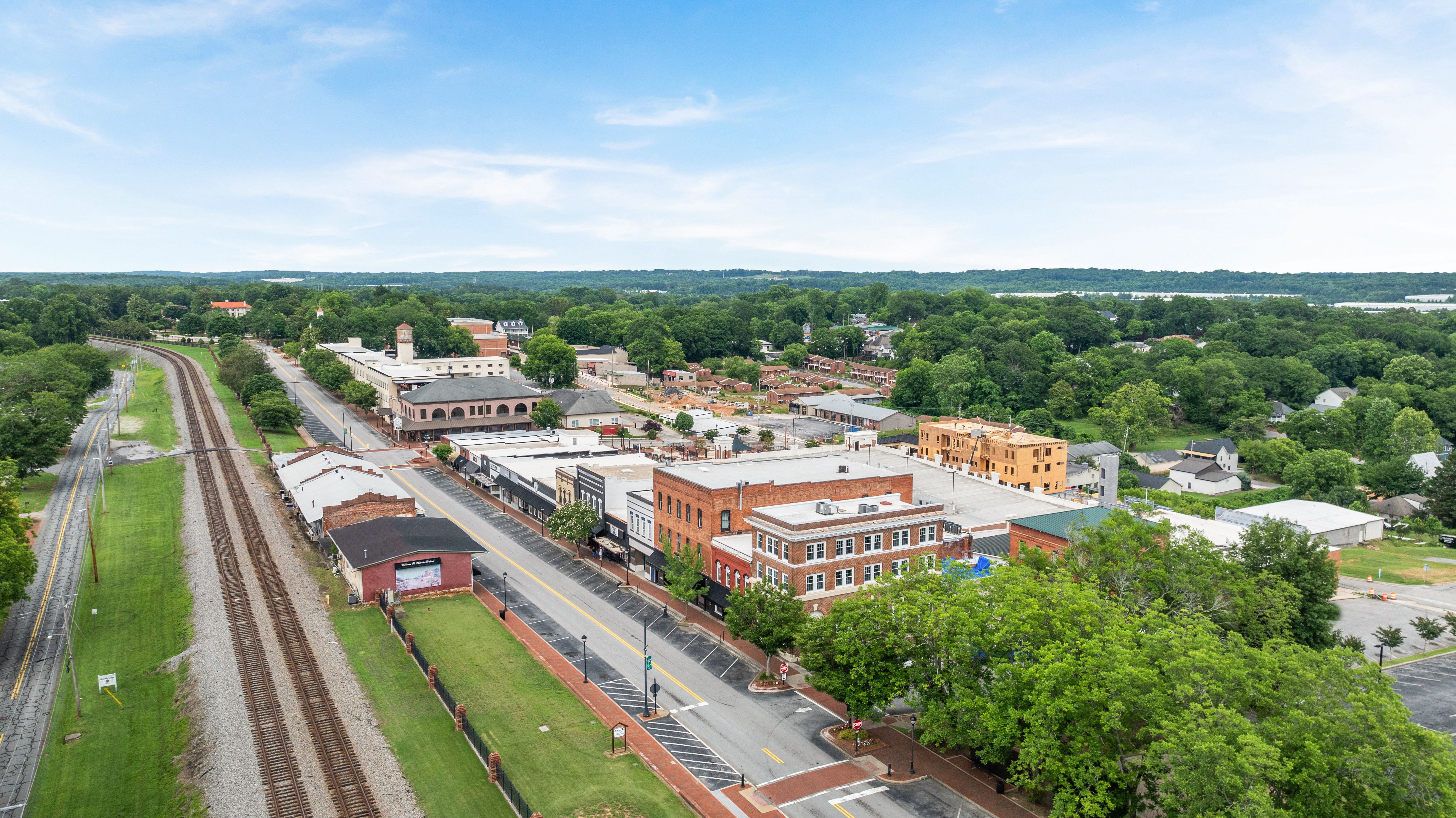 Aerial view of downtown Buford, Georgia, near the Fern Hollow community by Davidson Homes, featuring local historic buildings.