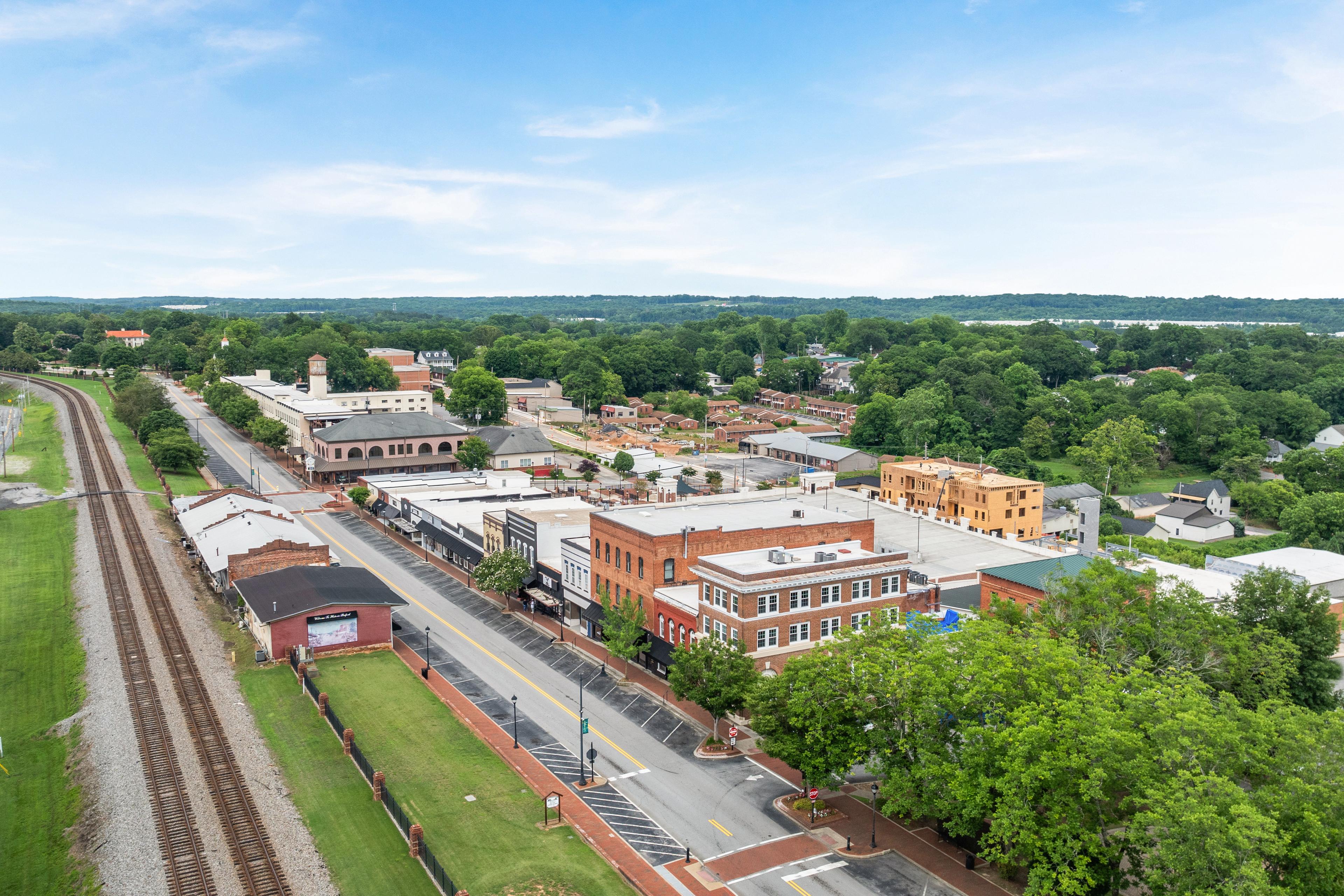 Aerial view of downtown Buford, Georgia, near the Fern Hollow community by Davidson Homes, featuring local historic buildings.