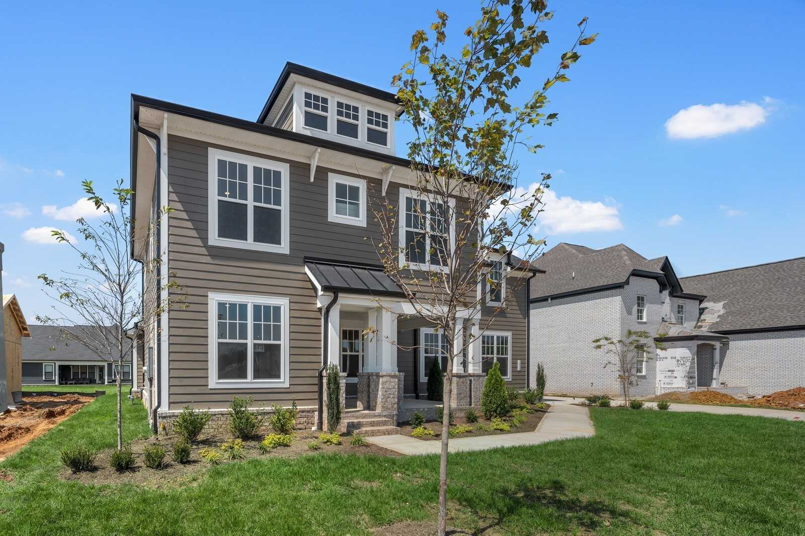 Two-story gray home with white trim, front porch, and landscaped yard in Shelton Square, Murfreesboro, TN - Davidson Homes The Hathaway