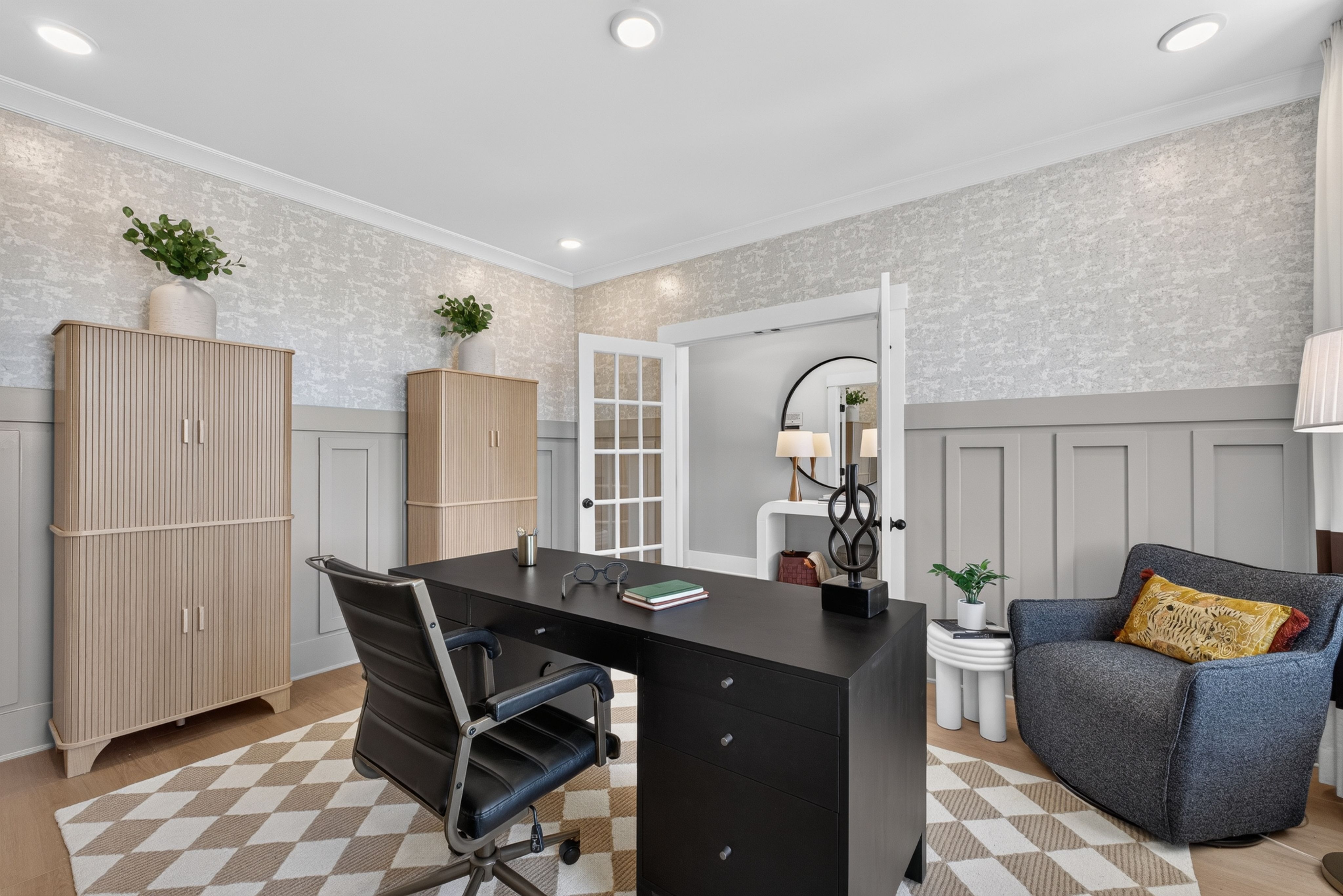 Stylish home office with black desk and wainscoting at Evergreen Mill by Davidson Homes in Madison, Alabama