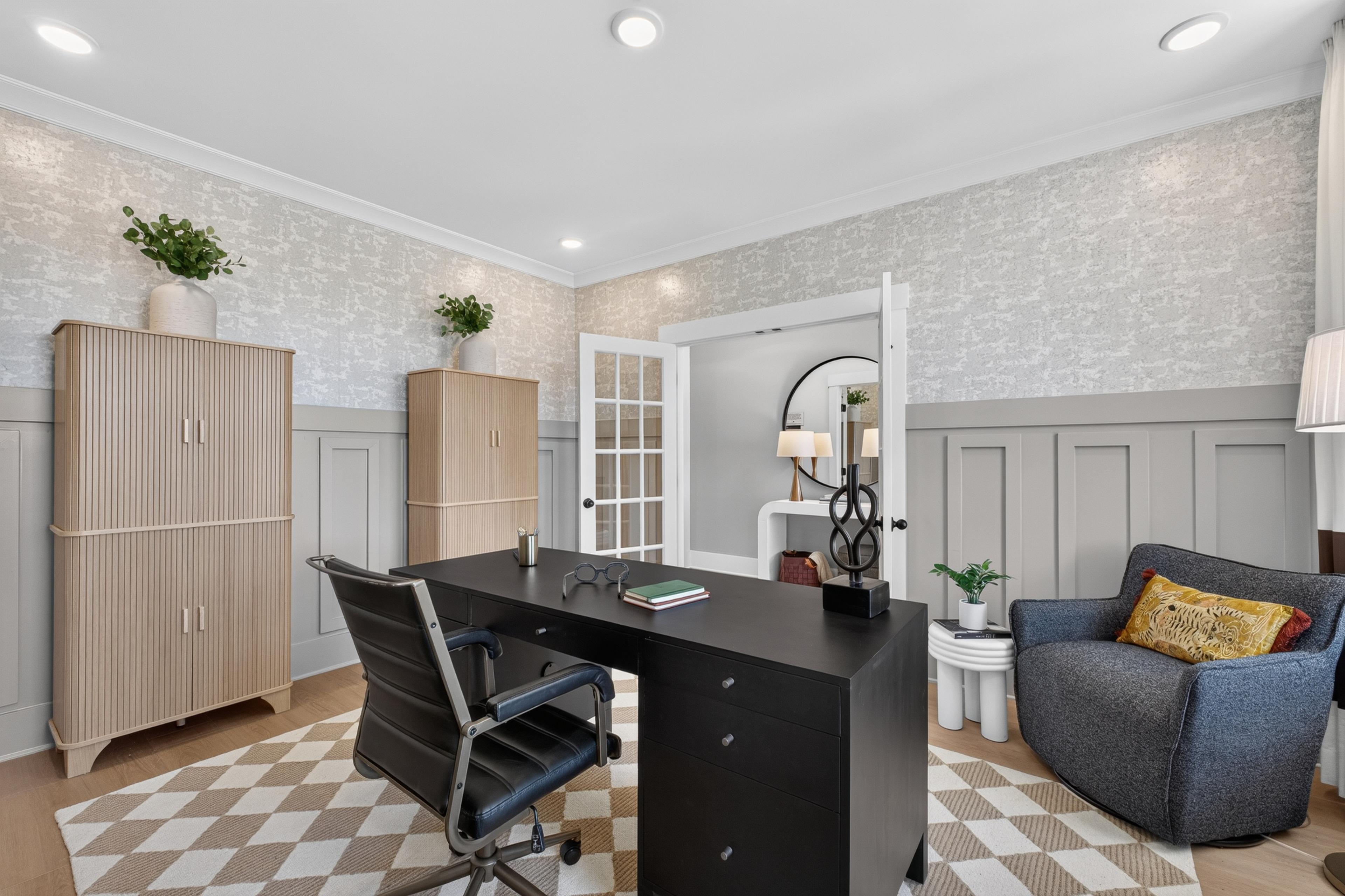 Stylish home office with black desk and wainscoting at Evergreen Mill by Davidson Homes in Madison, Alabama
