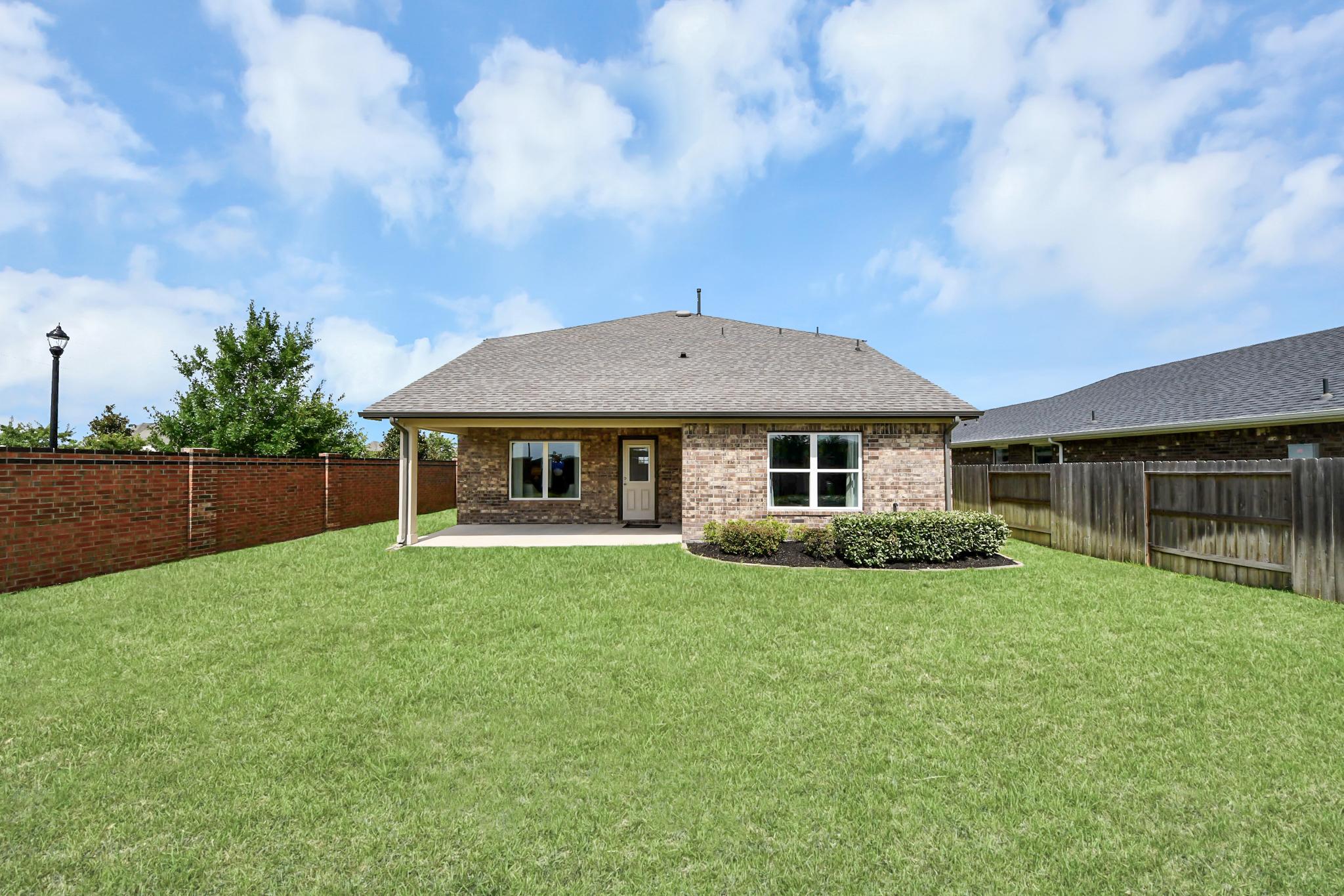 Spacious backyard with covered patio at a Davidson Homes property in Sunterra, Katy, Texas.