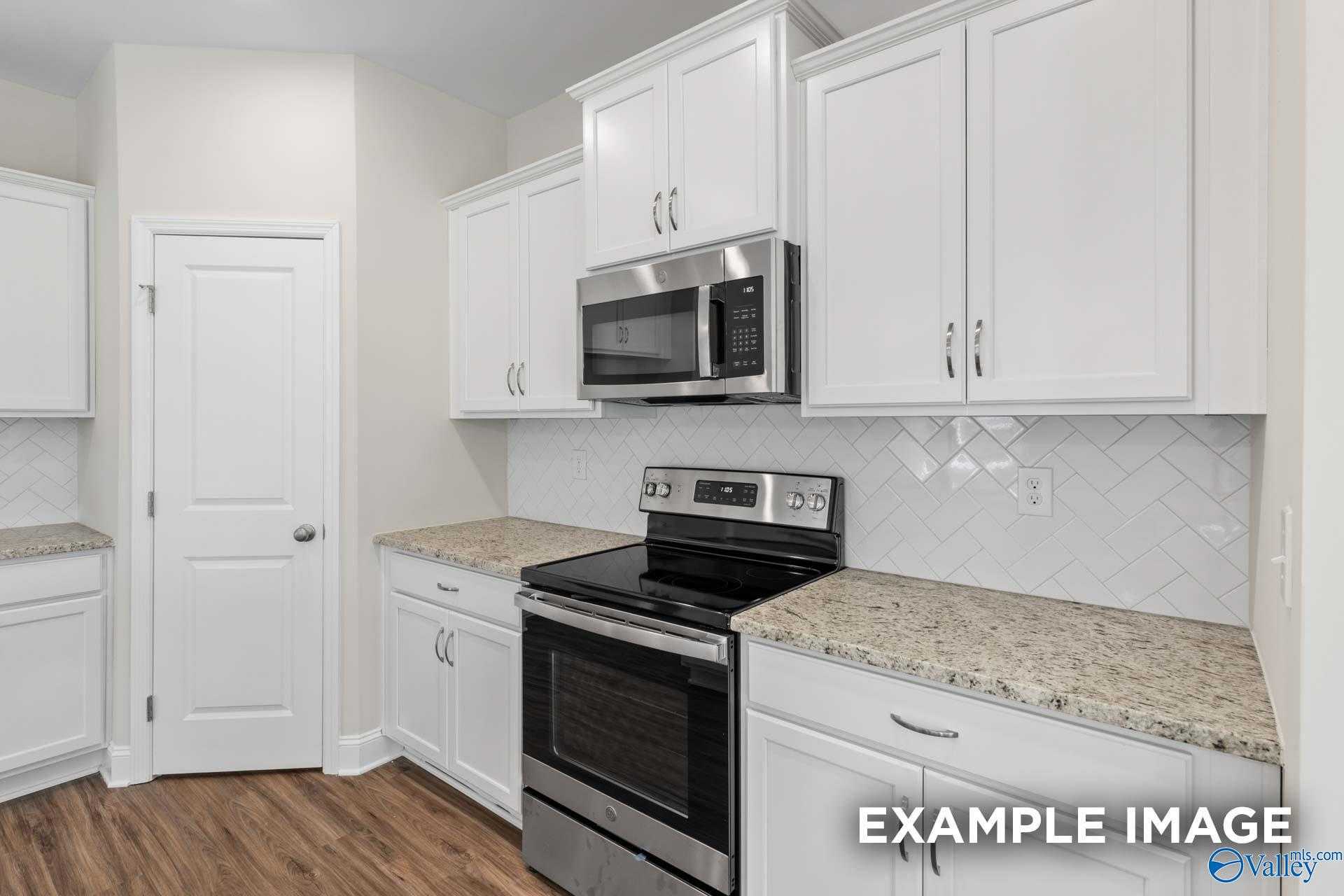 Modern kitchen featuring white cabinets, granite countertops, stainless appliances in Davidson Homes The Franklin, Meridianville, Alabama