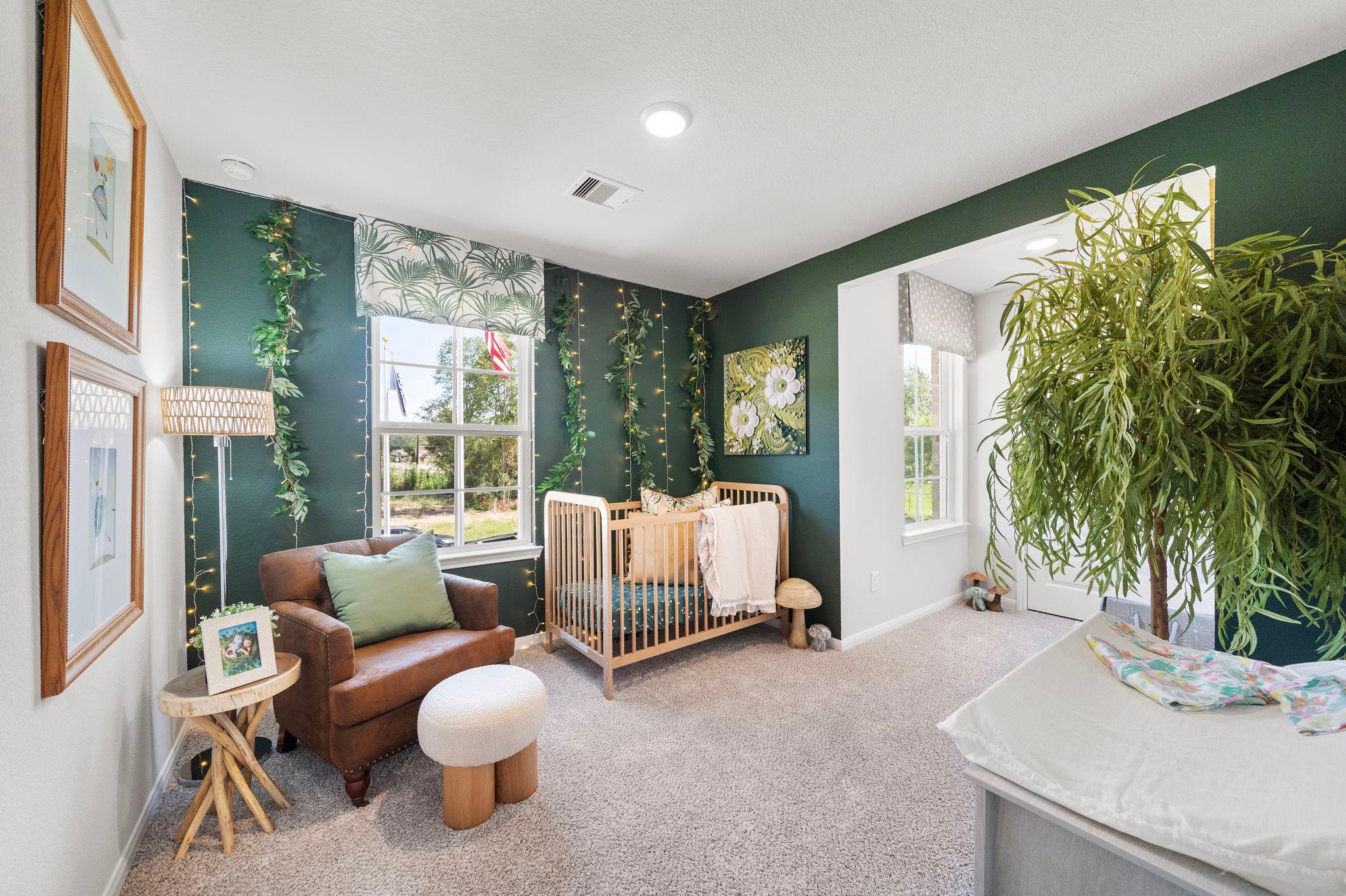 Cozy green nursery with wooden crib, leather armchair, potted plants and fairy lights at Caney Creek Place in Conroe Texas