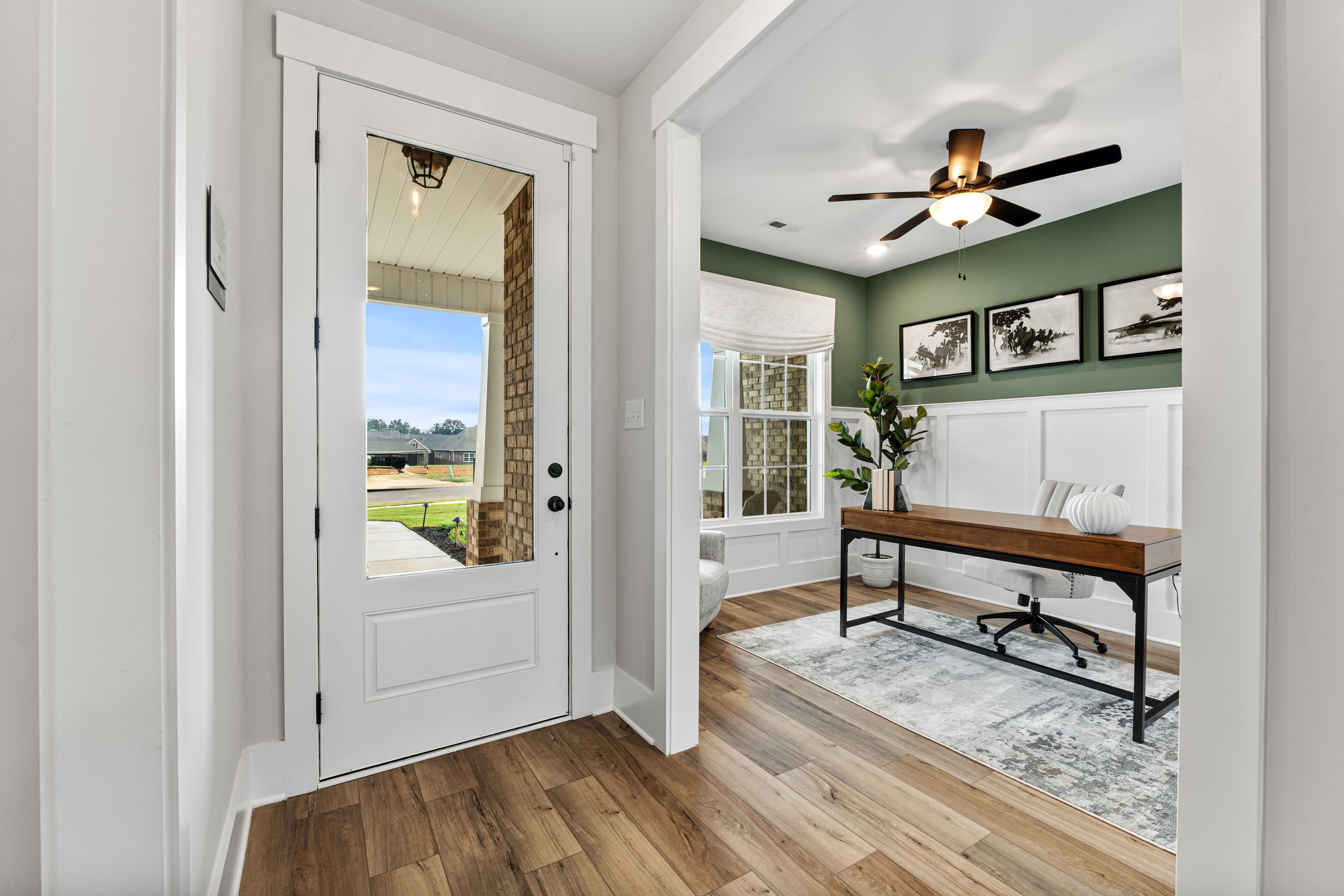 Cozy home office at River Road Estates in Decatur Alabama featuring sage green walls, wooden desk, and scenic window view