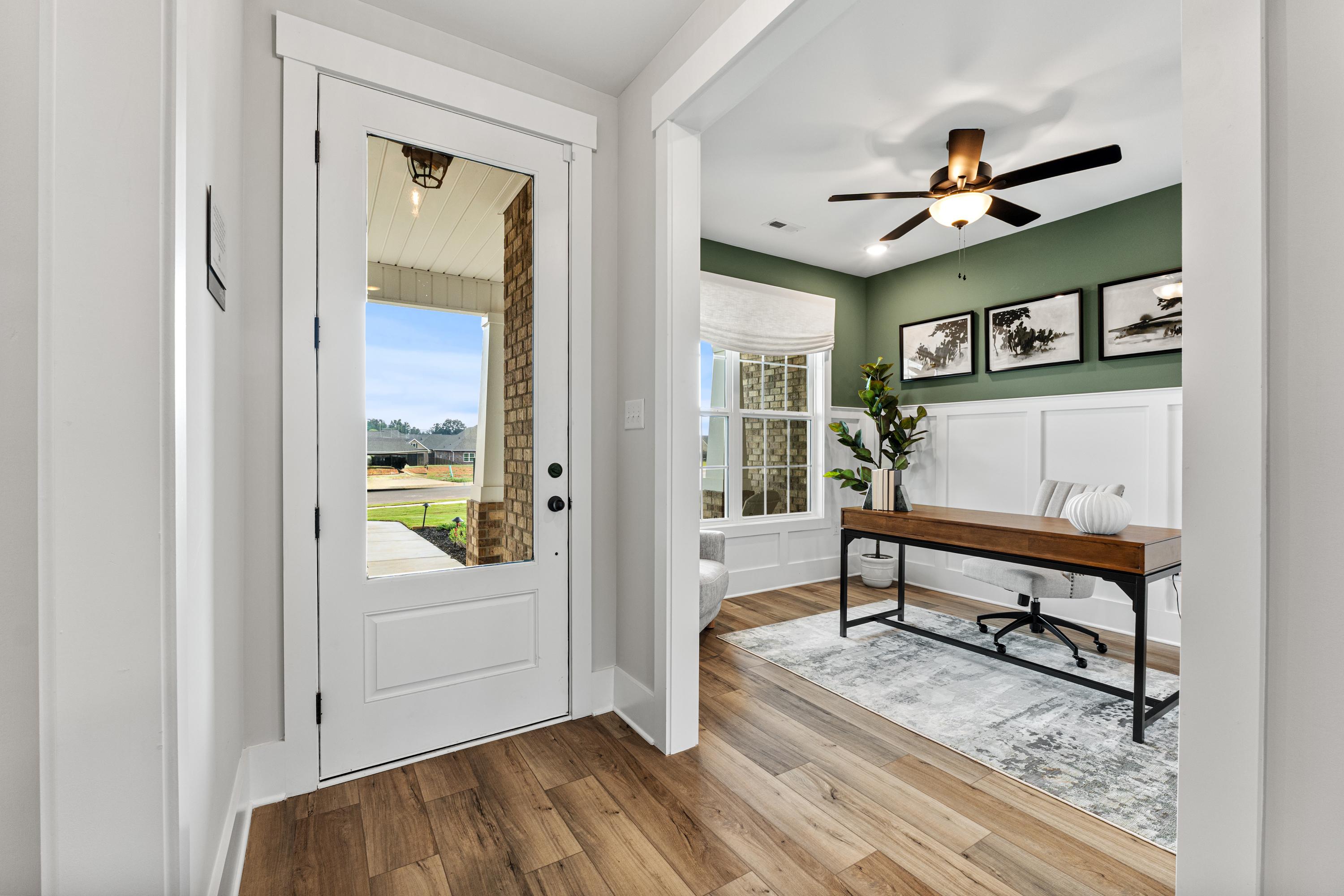 Cozy home office at River Road Estates in Decatur Alabama featuring sage green walls, wooden desk, and scenic window view
