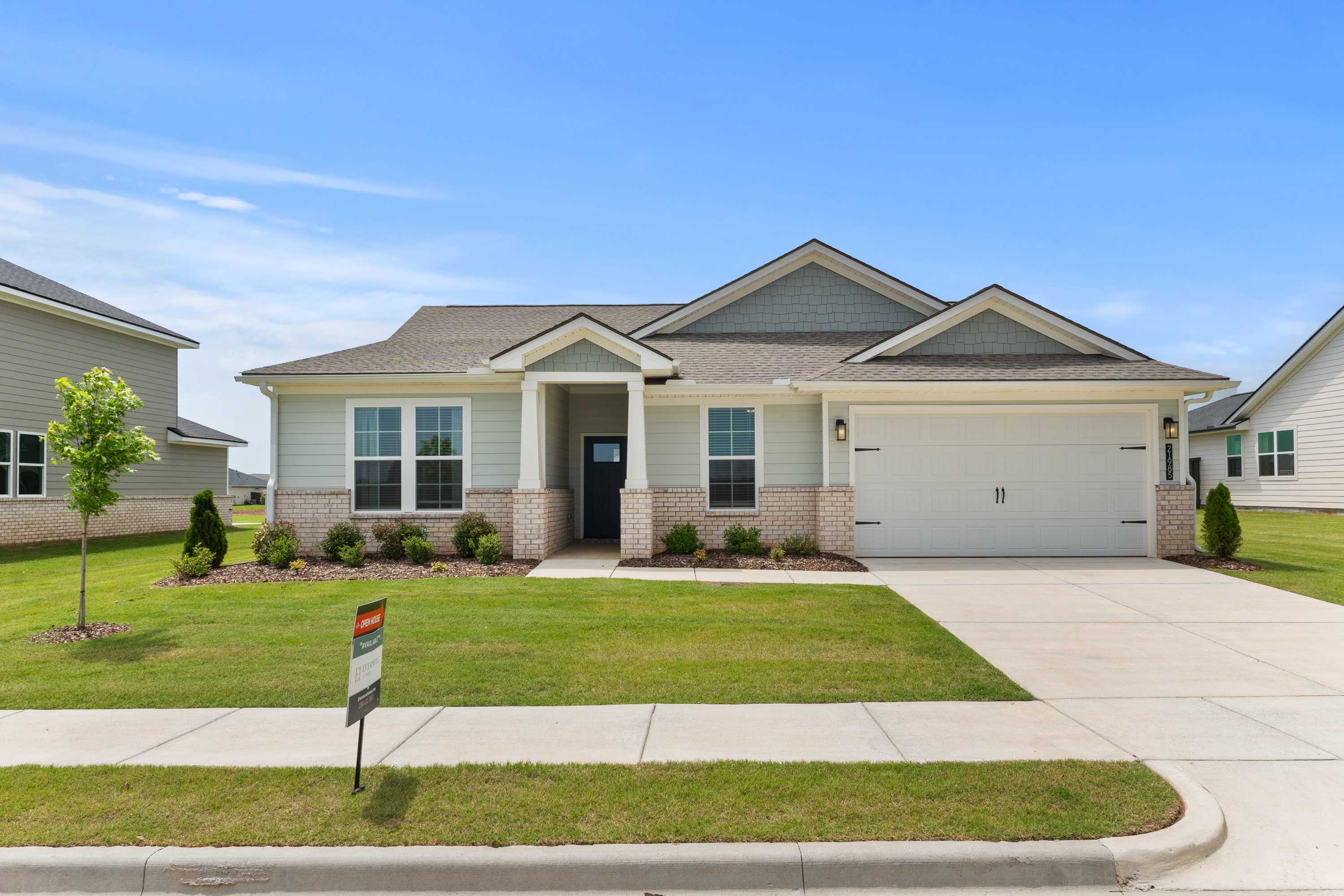 Modern craftsman home exterior at Anderson Farm in Athens Alabama featuring covered porch, garage, and lush front yard