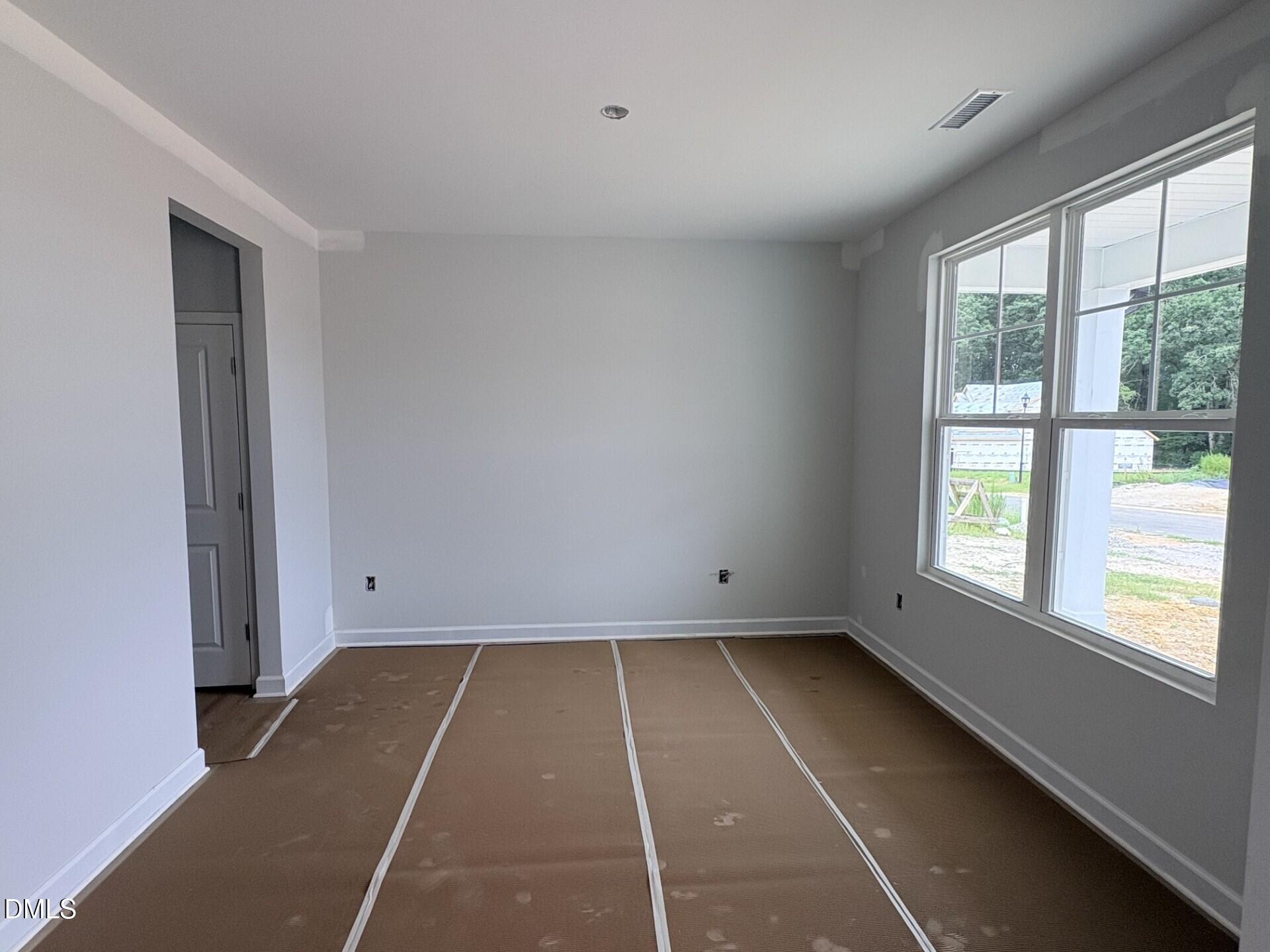 Bright, unfinished room with large windows in The Ash C floor plan by Davidson Homes in Woodland Crossing, Zebulon, NC.