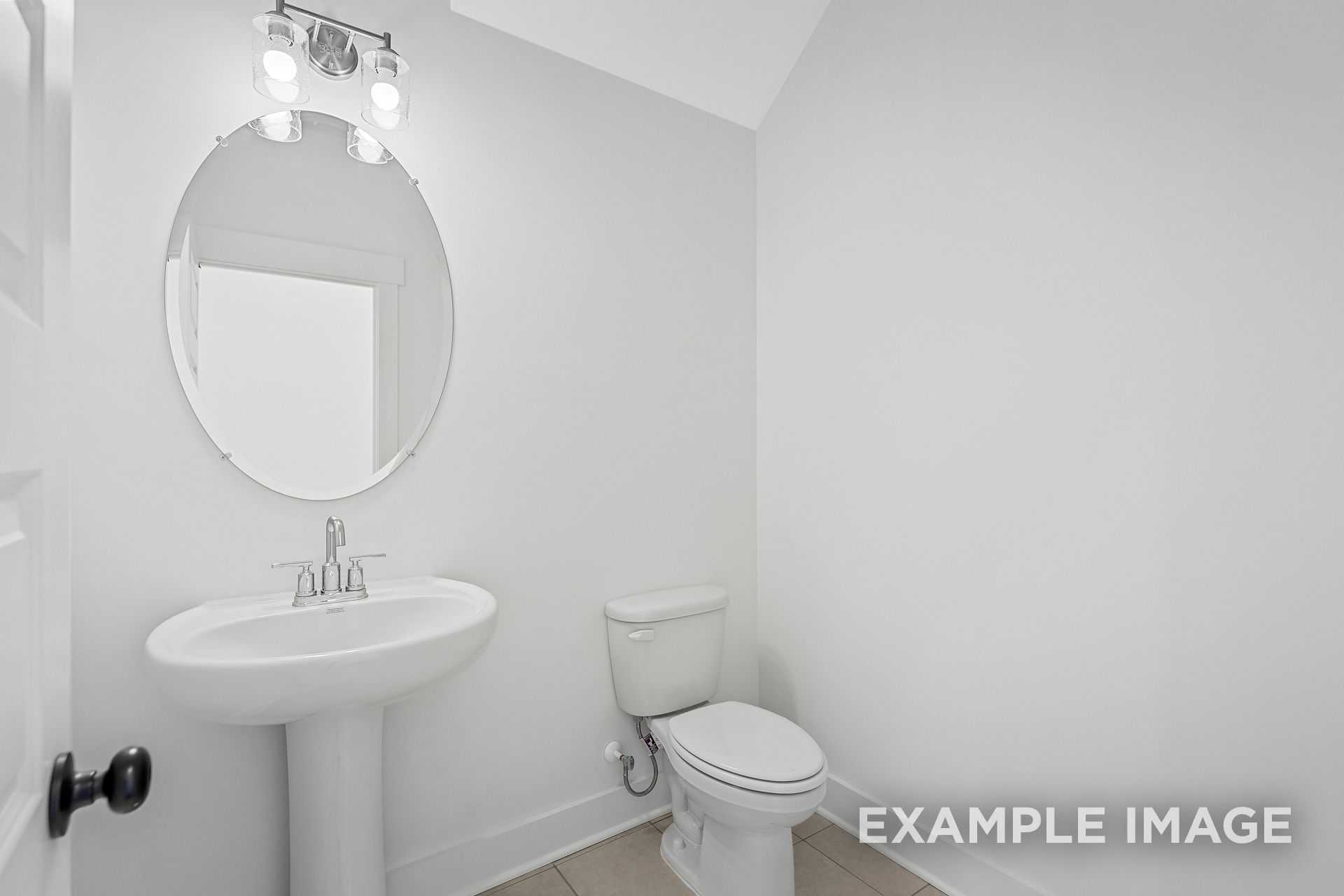 Bright white powder room in The Logan B by Davidson Homes, pedestal sink, round mirror, toilet