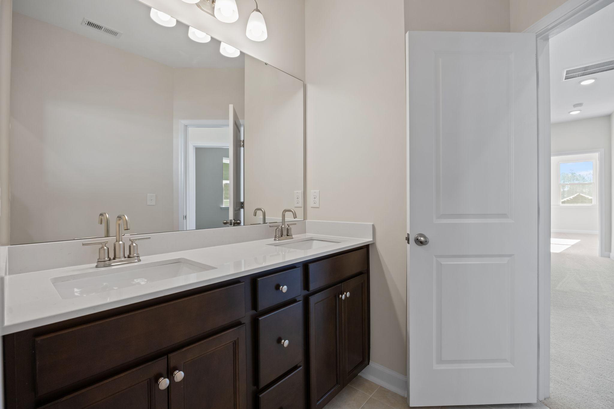 Modern dual-sink bathroom vanity with dark cabinetry and quartz countertops at Forestville Yard in Knightdale, NC.