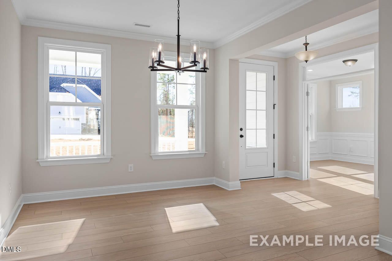 Elegant dining room with chandelier, large windows, hardwood floors in The Crawford D by Davidson Homes, Angier, NC