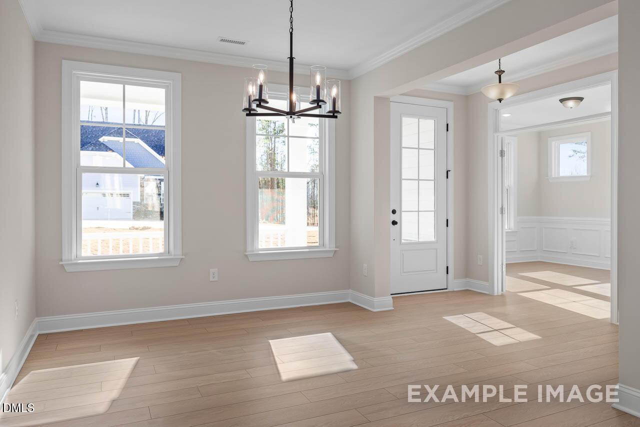 Elegant dining room with chandelier, large windows, hardwood floors in The Crawford D by Davidson Homes, Angier, NC