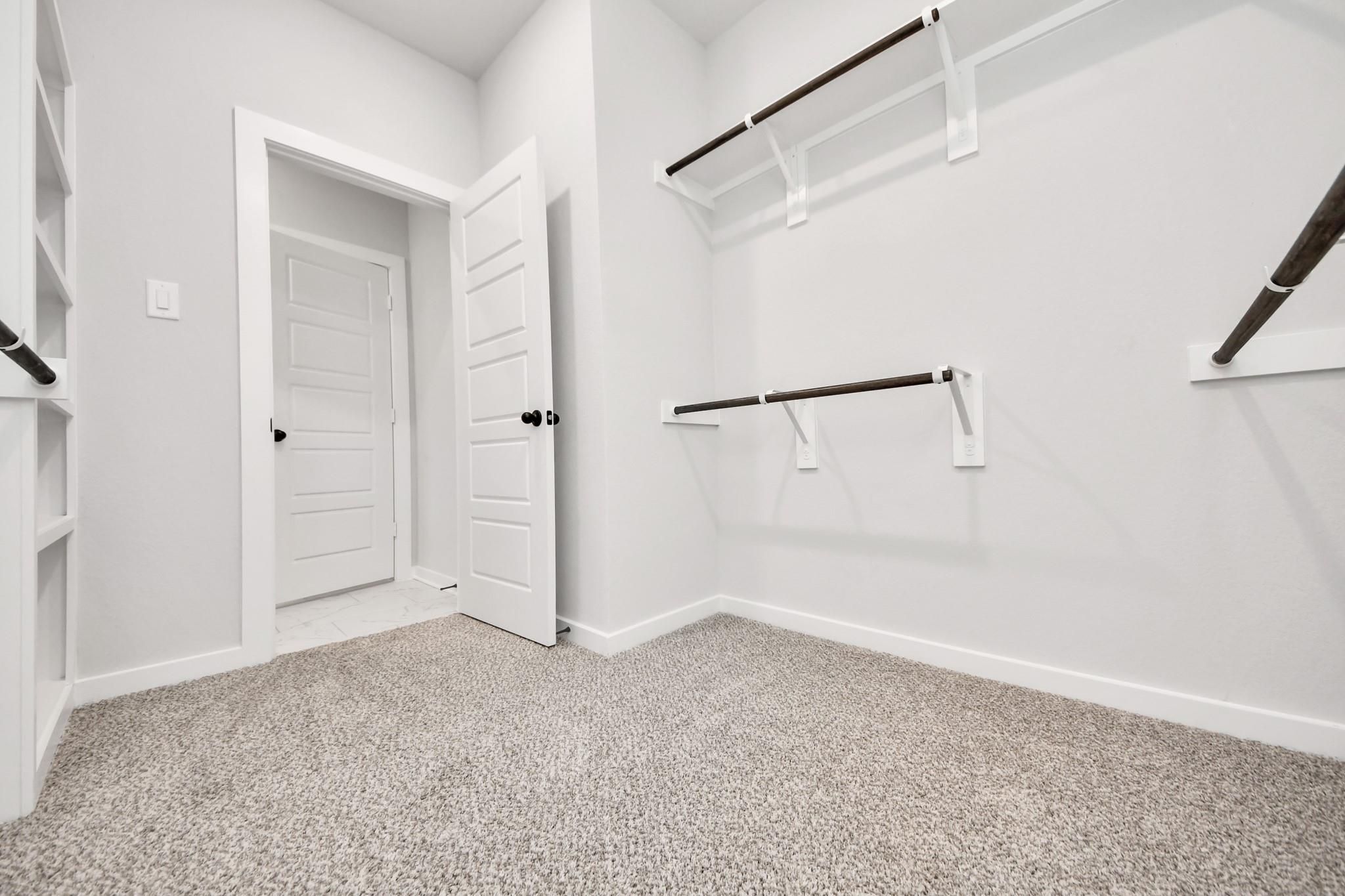 Walk-in closet with built-in shelving in The Sorrento E floor plan at Sundance Cove, Crosby, Texas.